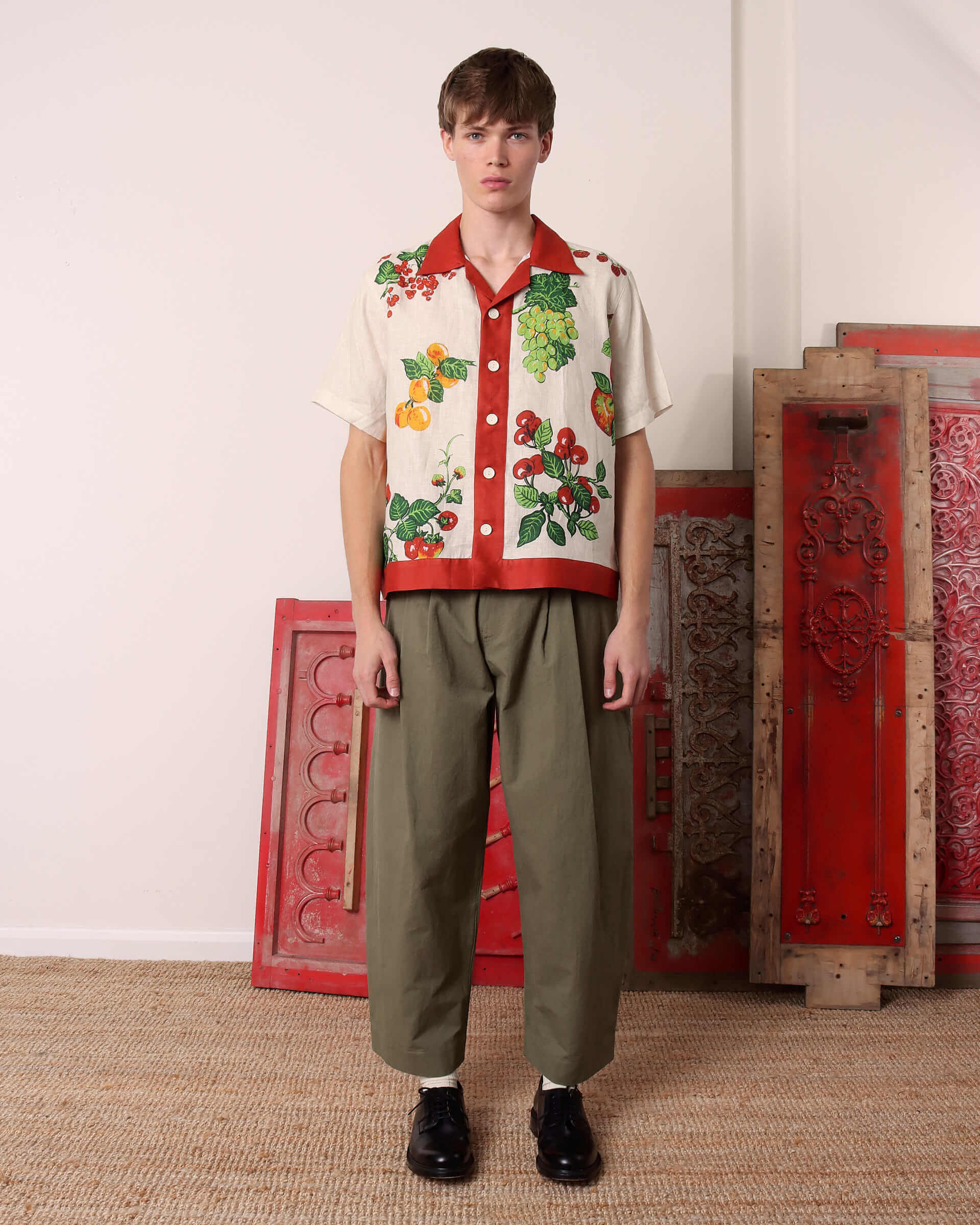 A model wears the 'Picnic' Short Sleeve Shirt paired with the green 'Clarence' Trousers.