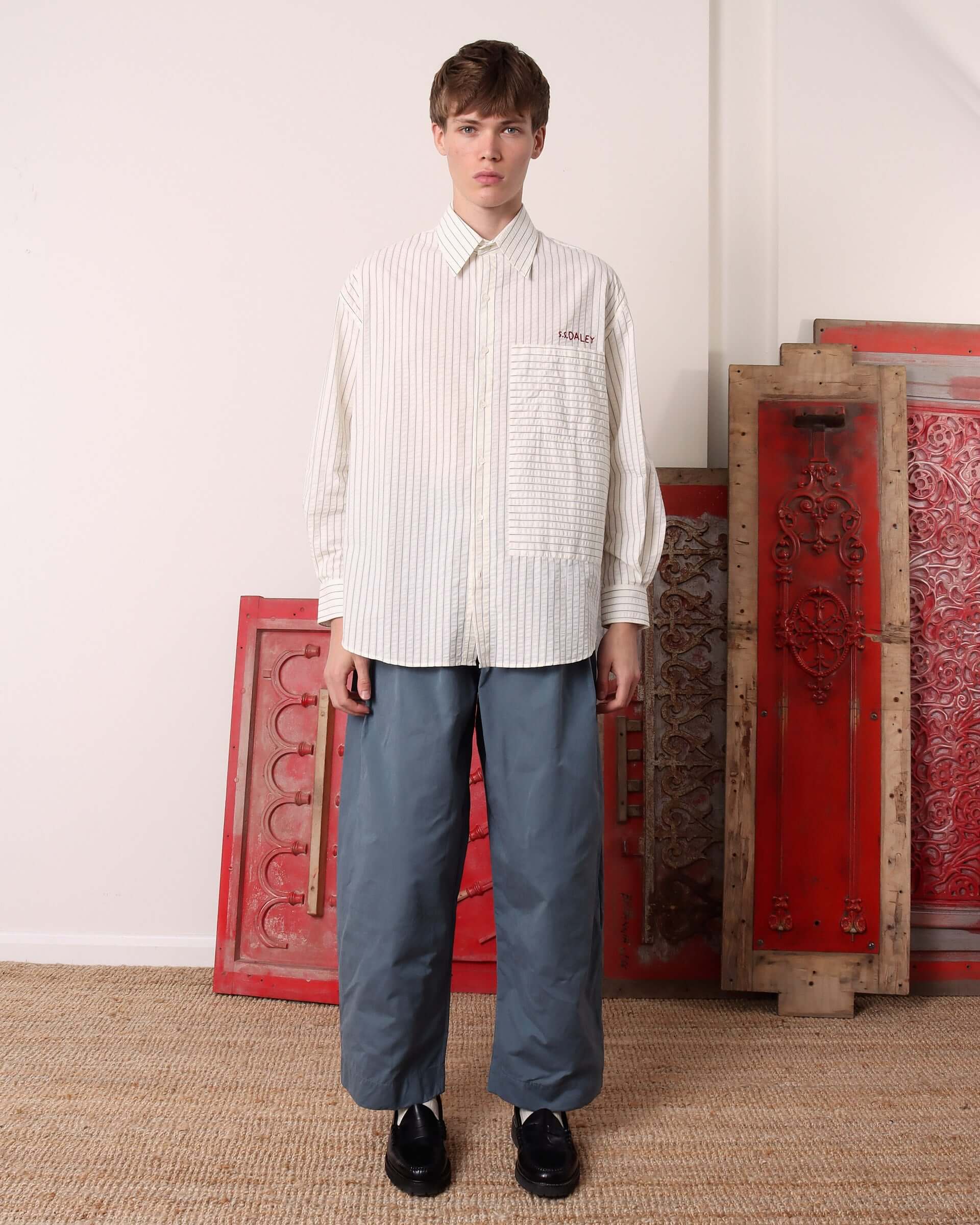 A model wears the Striped 'Cuthbert' Shirt with long sleeves.