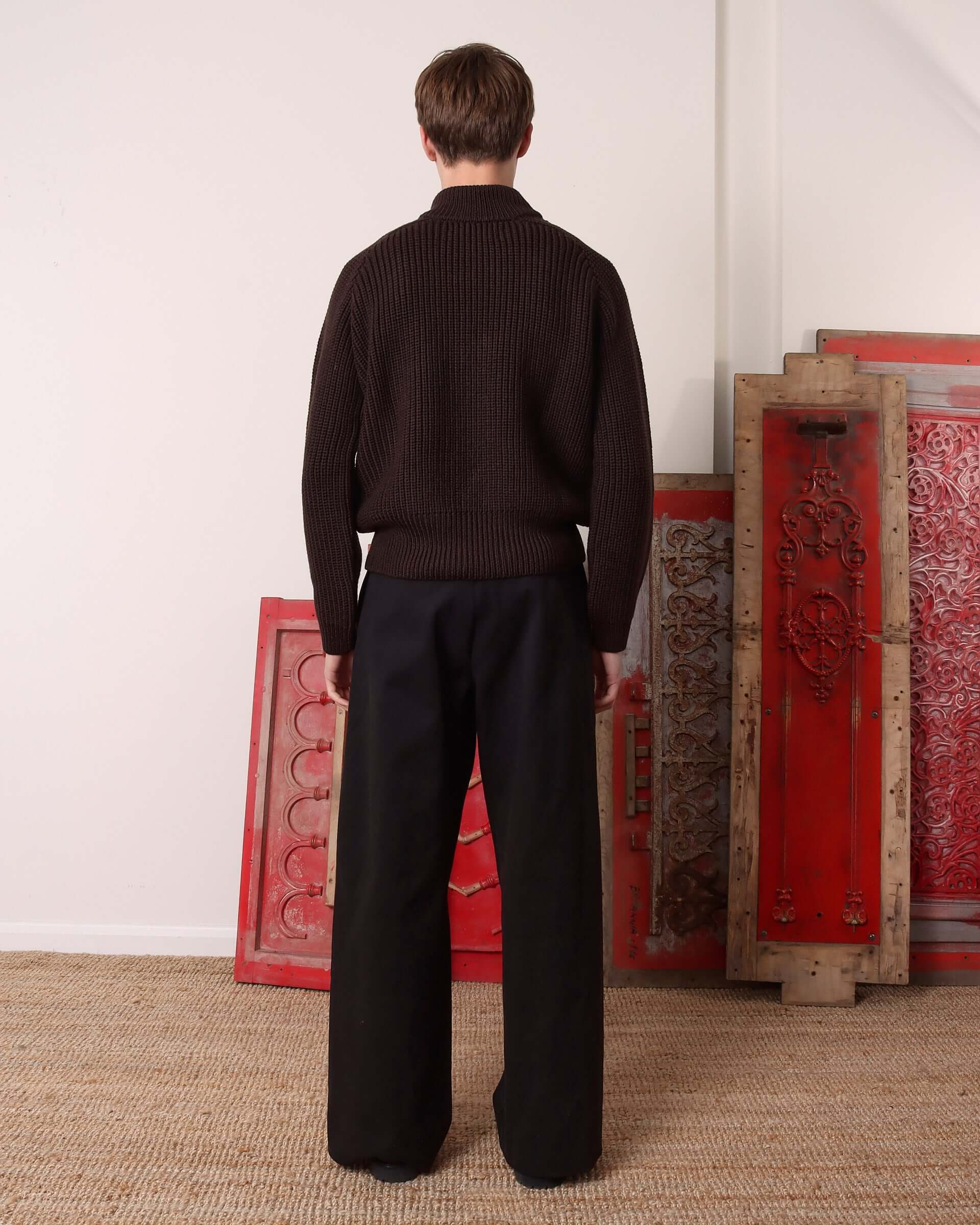 A model wears the 'Circle' Sweater in brown marino wool and shows the back and its chunky, sweater fit.