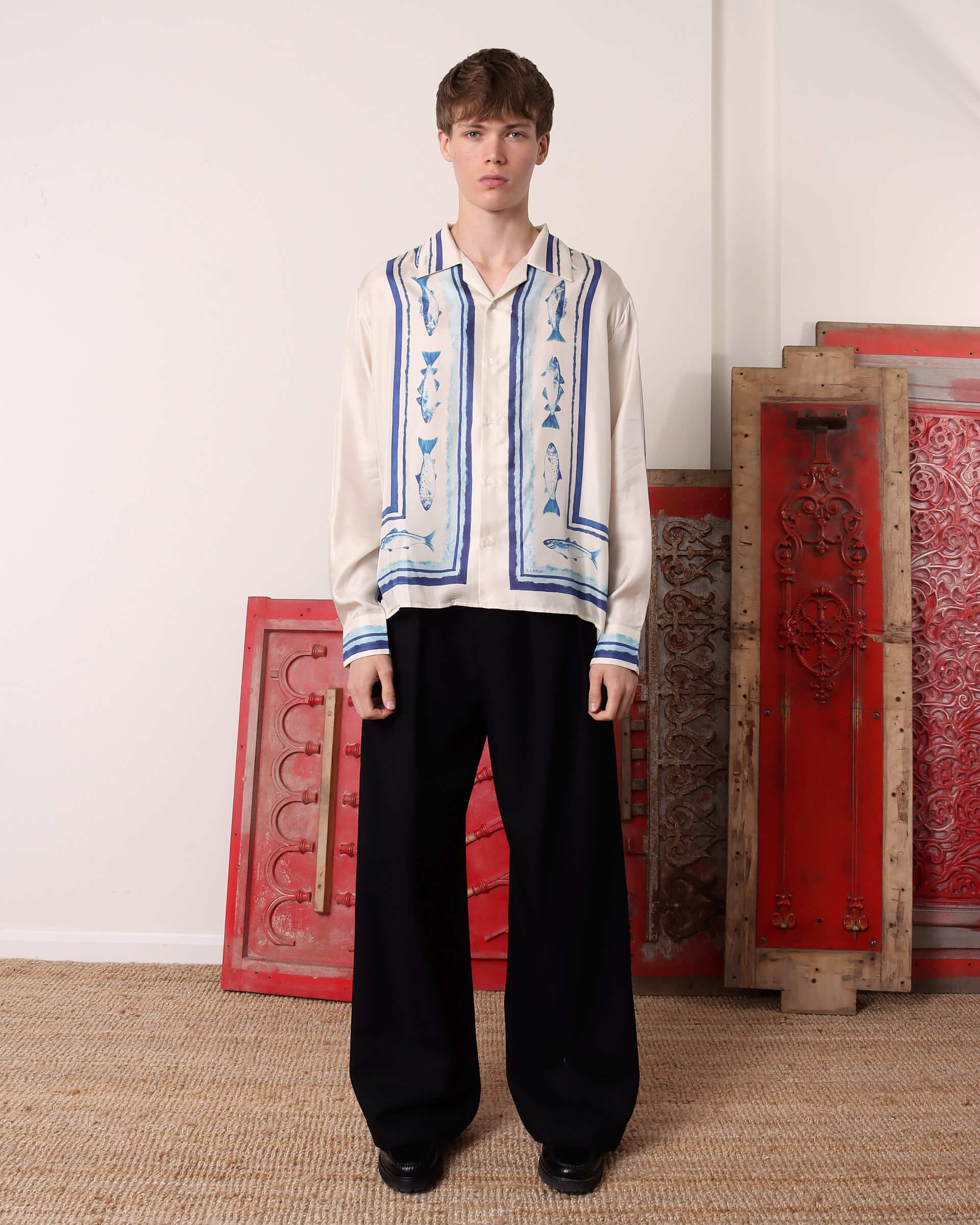 A model wears the silk long sleeve 'Elliot' Shirt with a pair of black trousers.