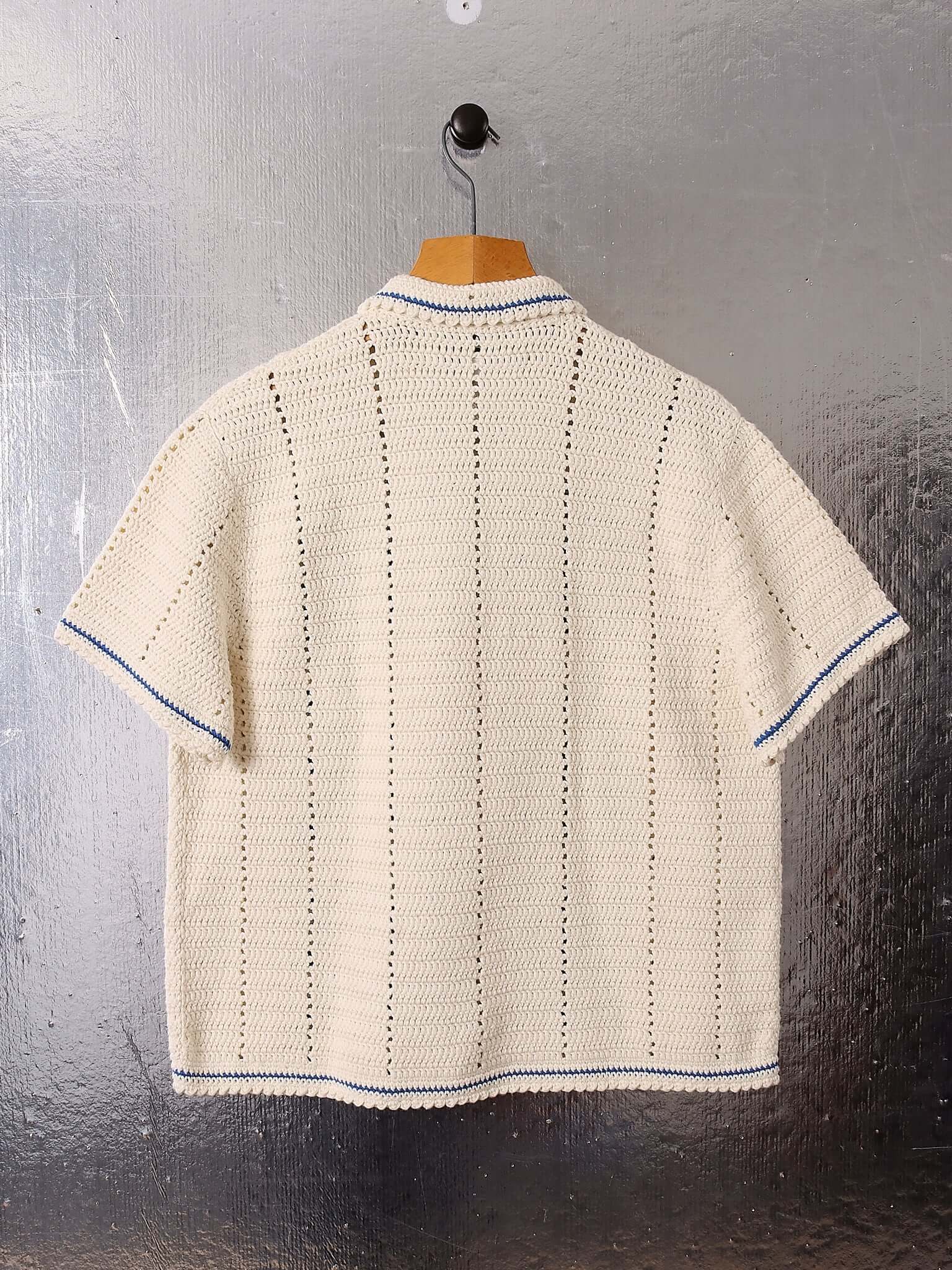 A flat shot of the back of the 'Abel' Crochet Shirt in cream crochet with blue details.