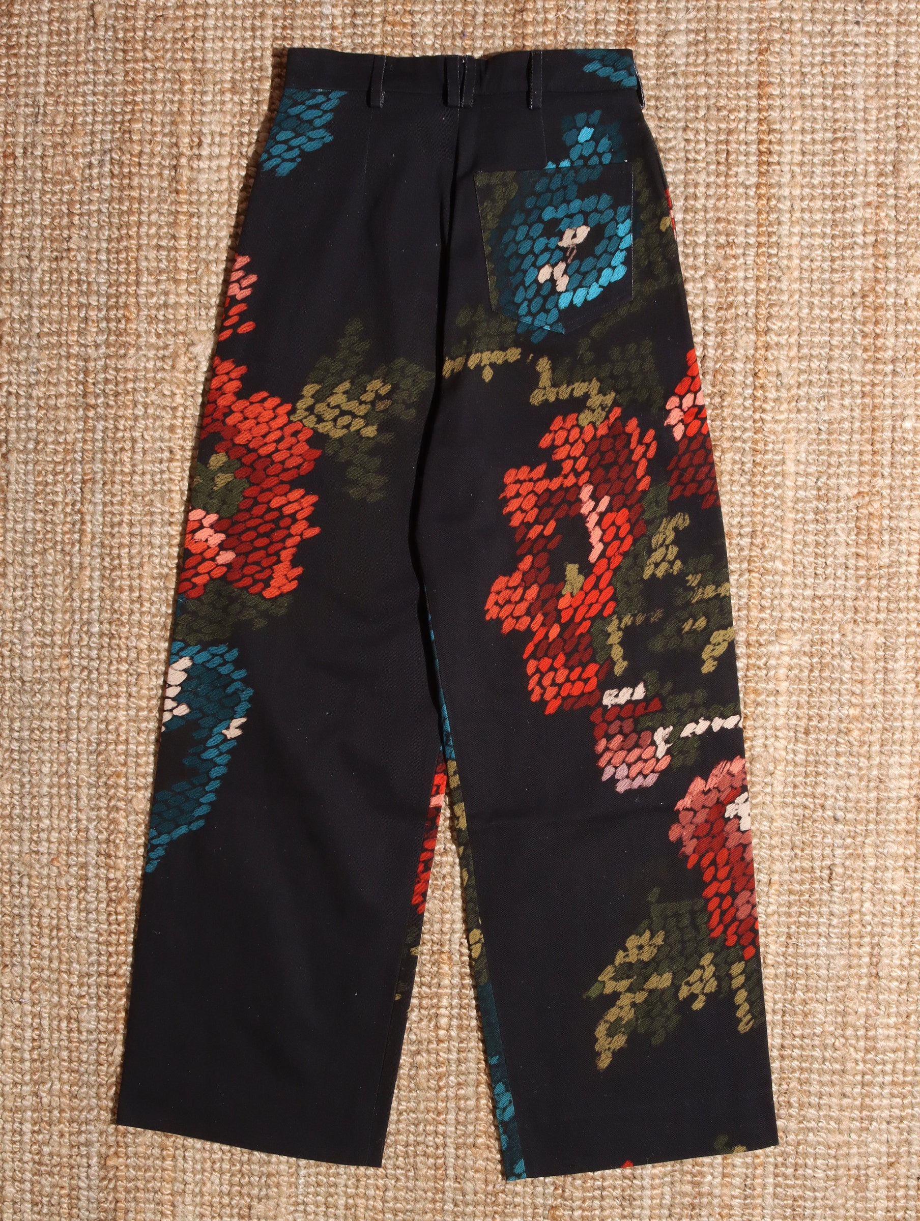 A flat shot of the black and floral 'Spry' Trousers showing the back.
