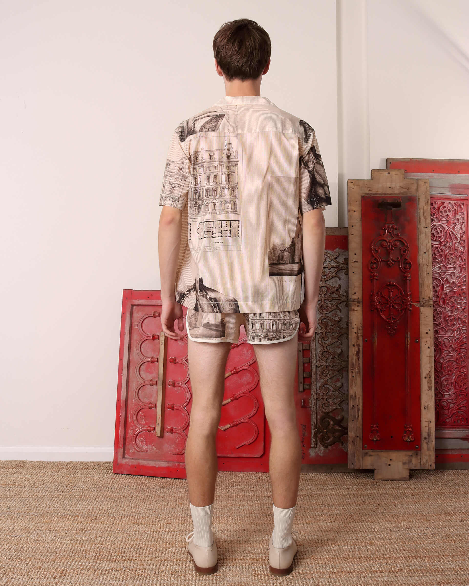 A model shows the back of the 'Estate Sale' Shirt and matching drawstring shorts.