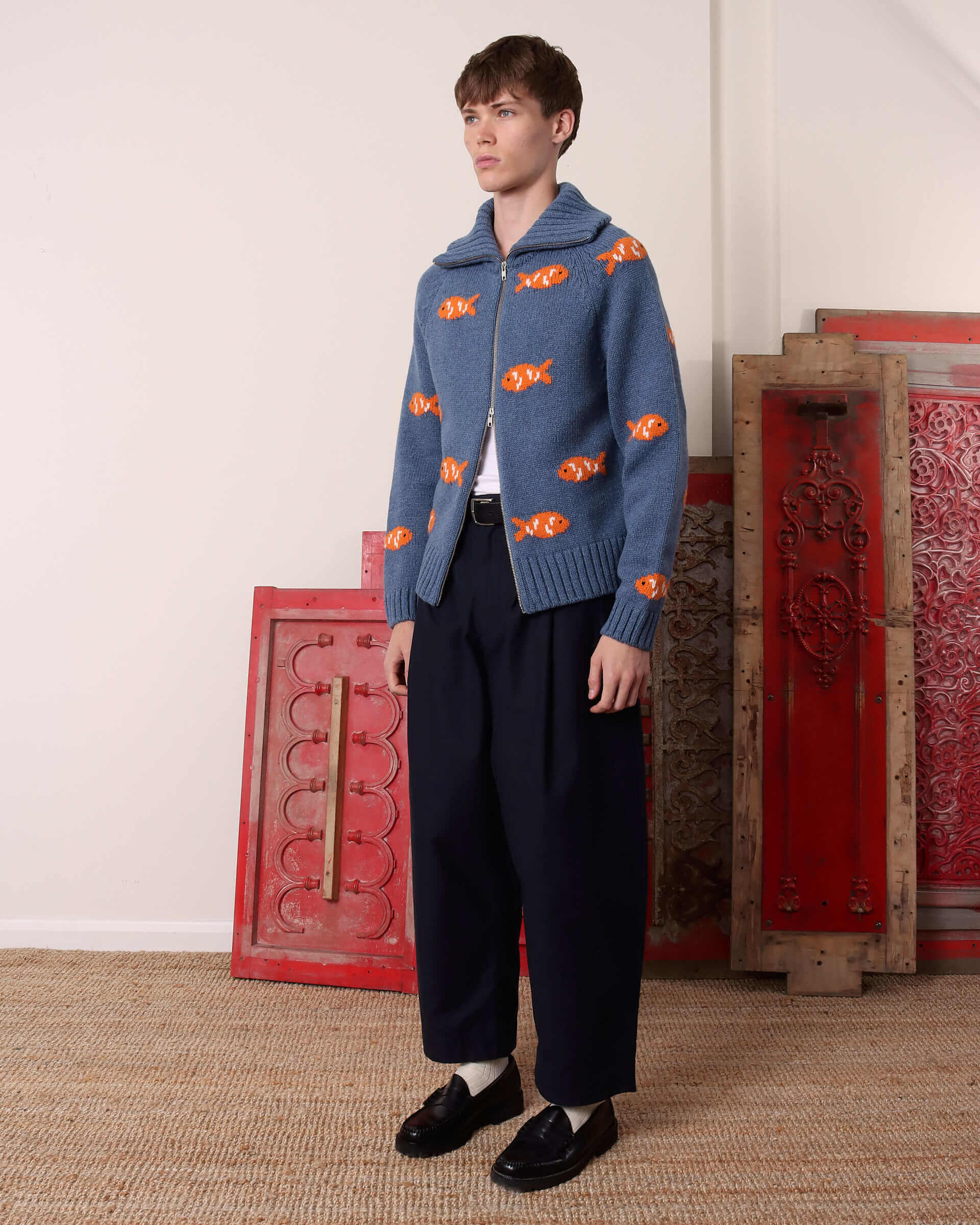 A model shows the side of the 'Archie' Knit with the ribbed collar folded down.