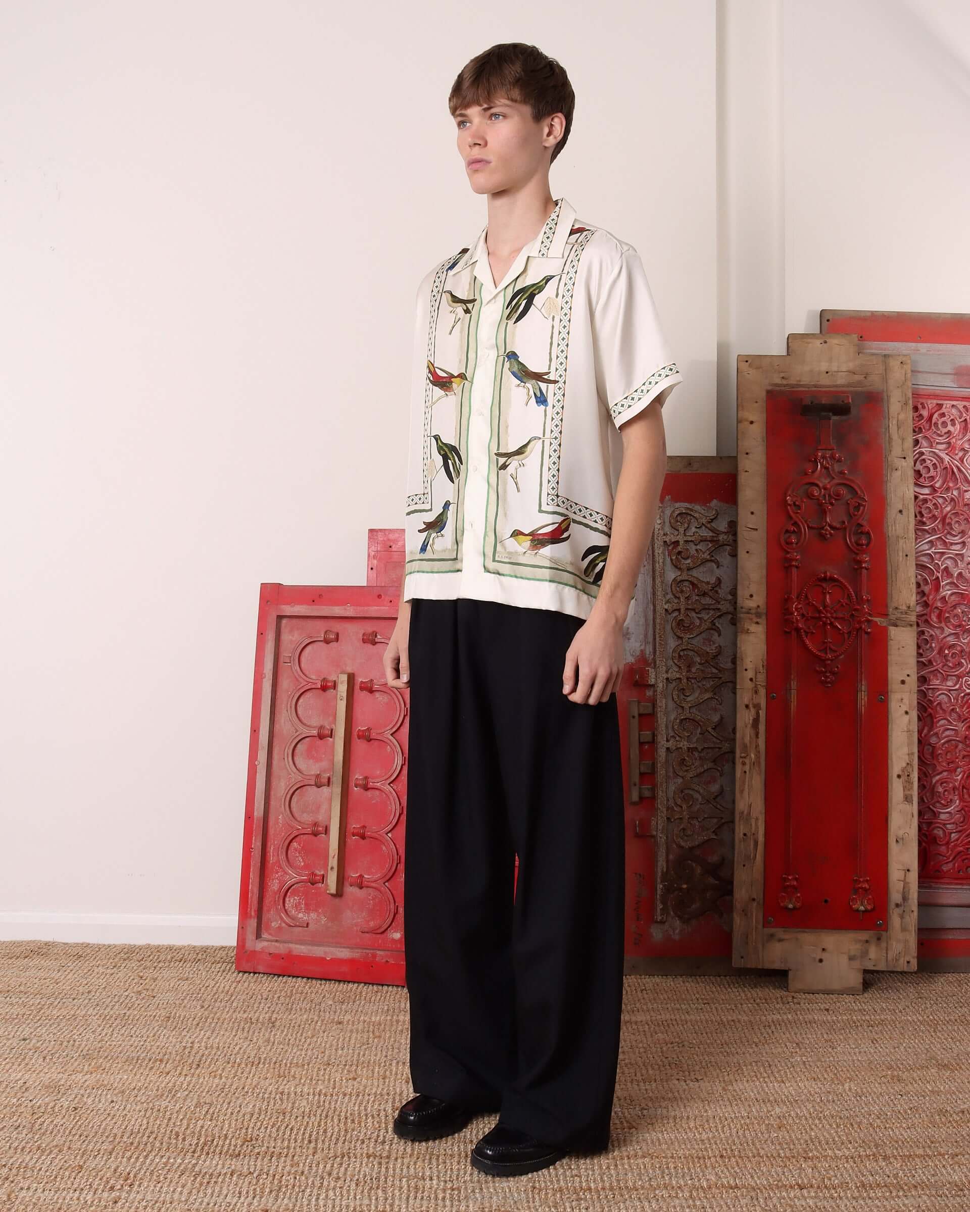 A model shows the side of the silk 'Birdwatcher' Short Sleeve Shirt untucked.