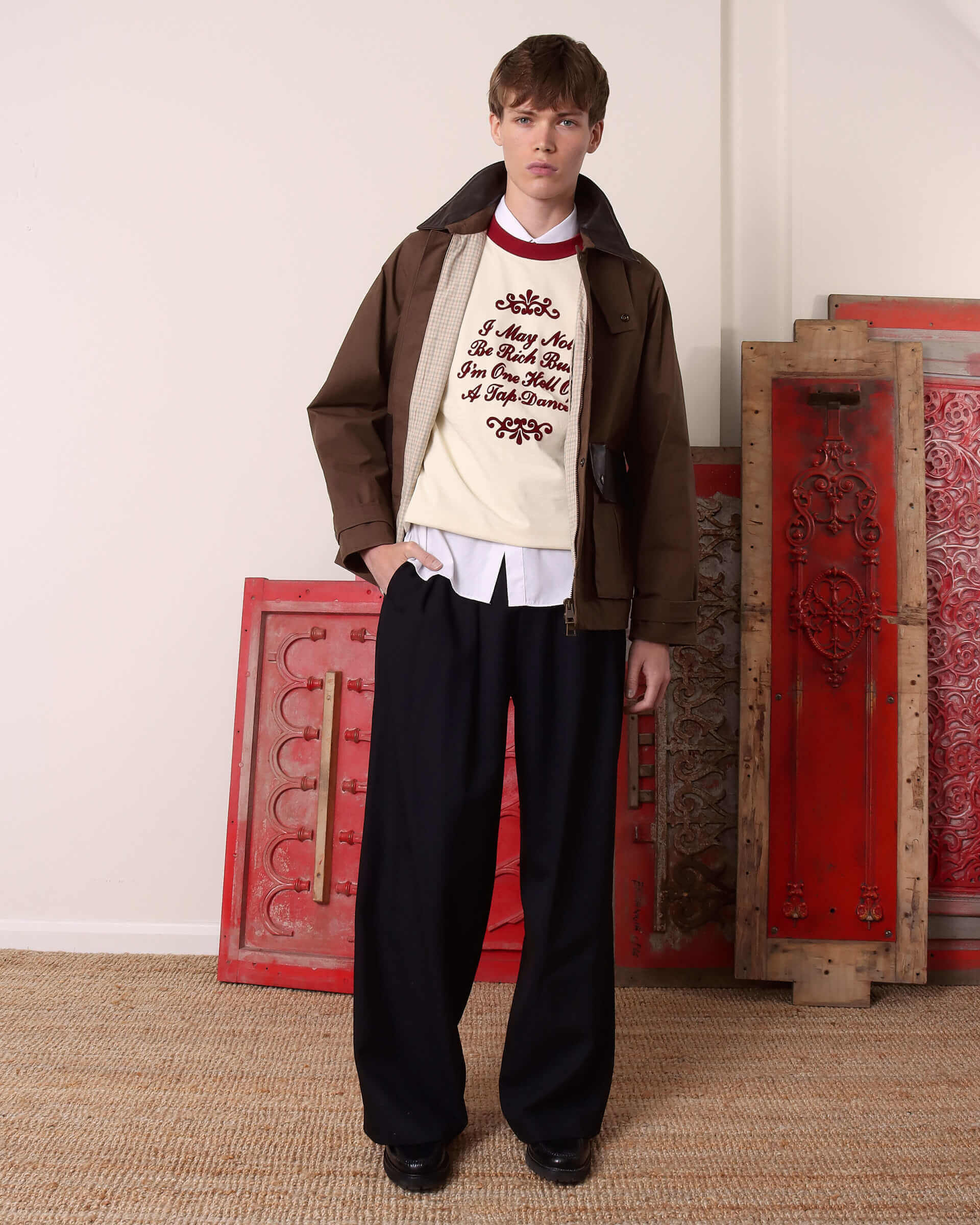 A model wears the 'Theodore' Waxed Blouson open, showing the check lining and styled with the collar up.