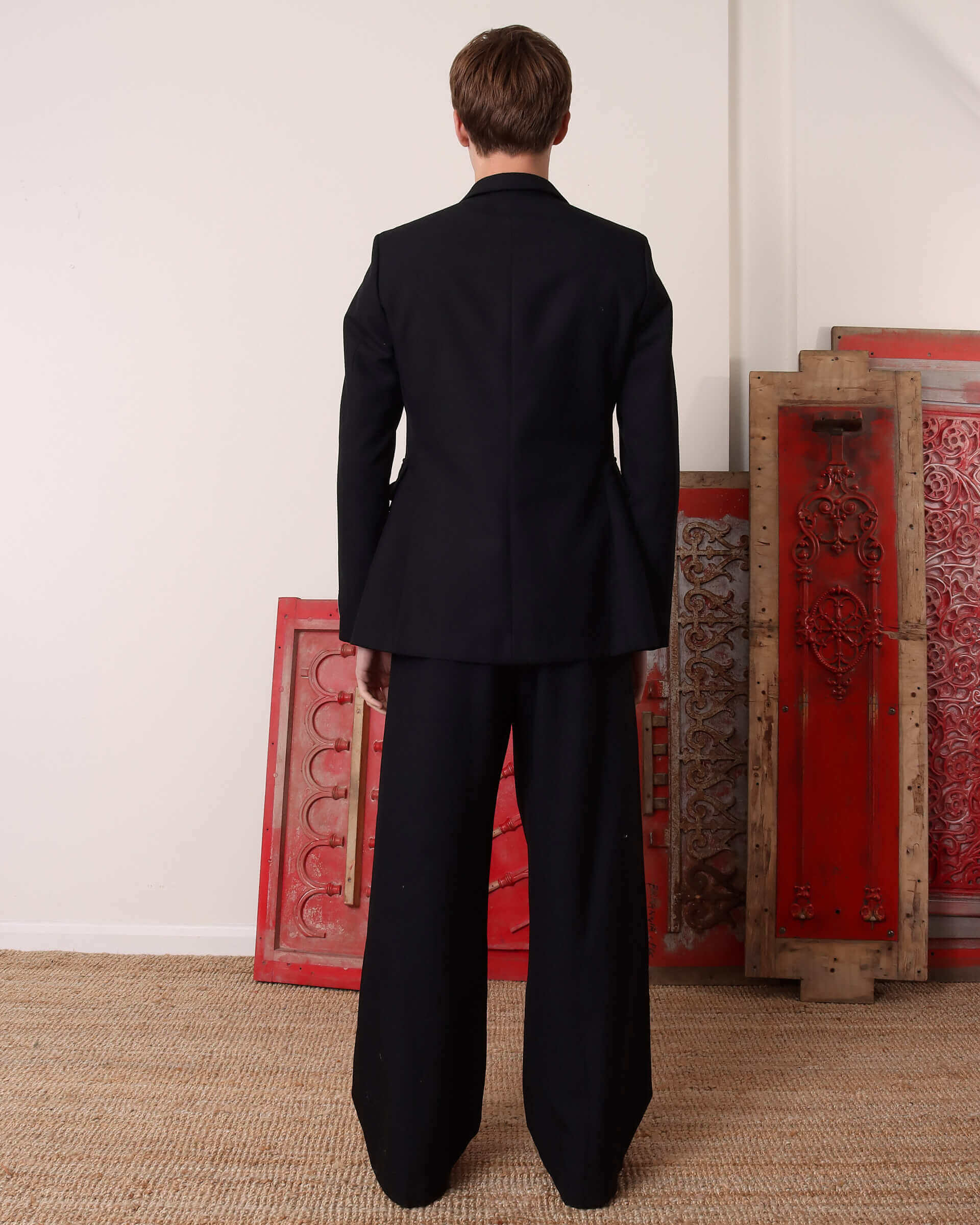 A model shows the back and structure of the 'George' Single Breasted Suit Jacket .