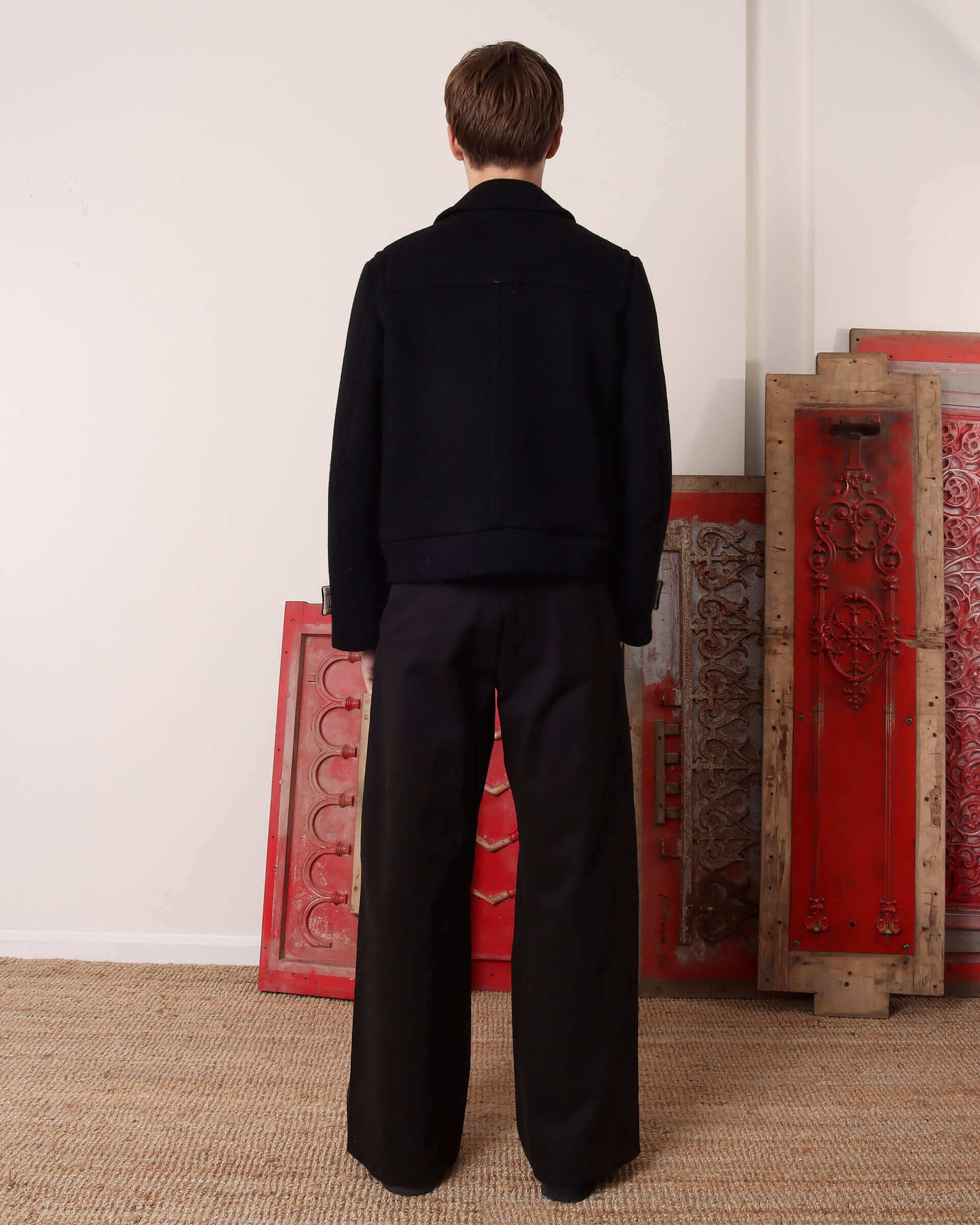 A model shows the back of the 'Alwyn' Duffle Jacket and its folded collar.