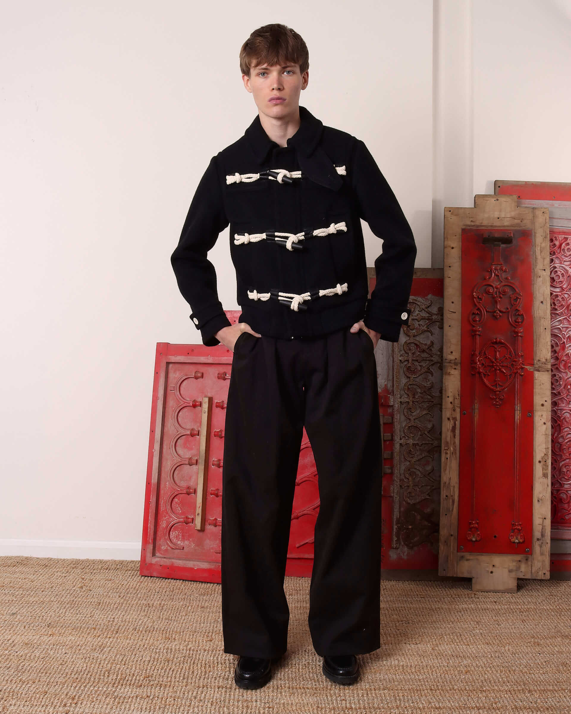 A model wears the 'Alwyn' Duffle Jacket zipped up to the collar with the braided rope fastenings with wooden toggles closed.
