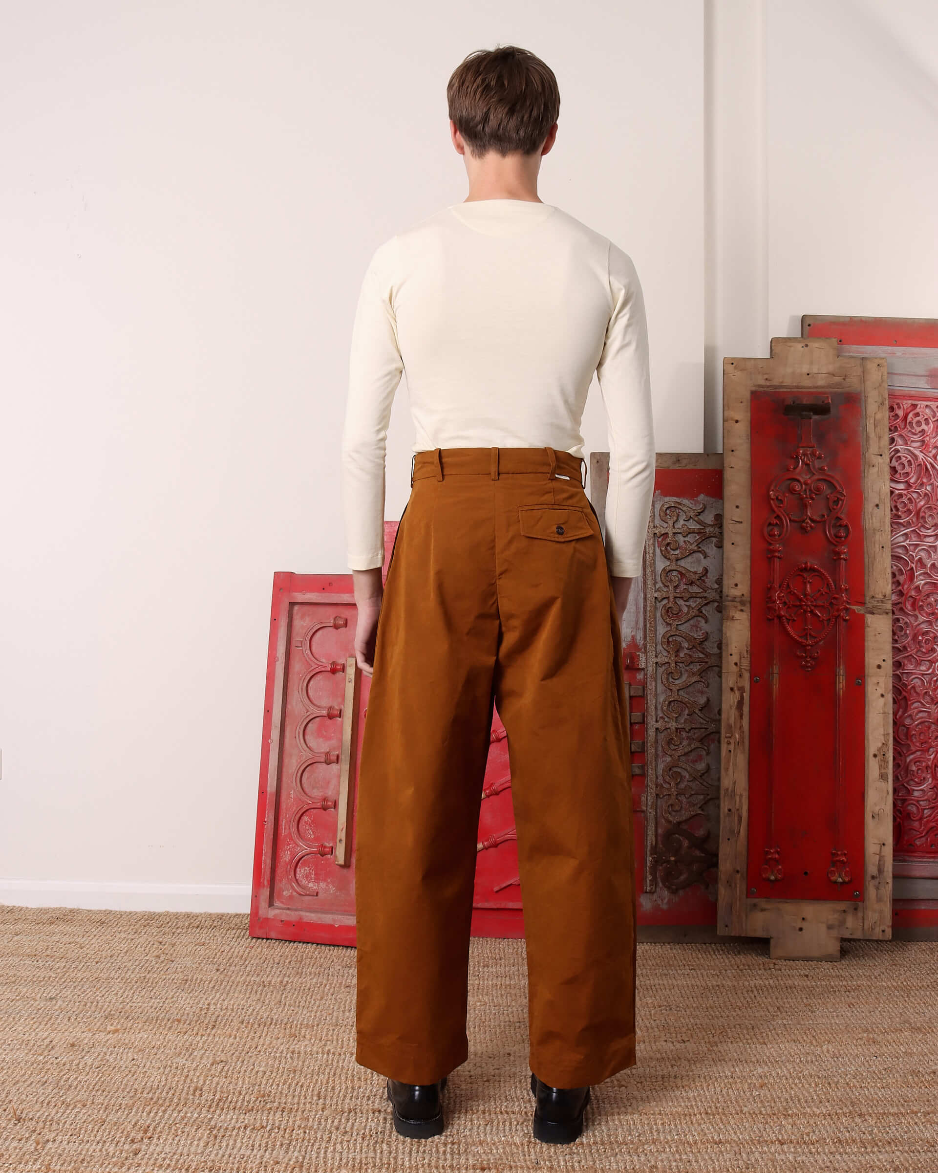 A model shows the back of the 'Morris' Trouser in ochre.