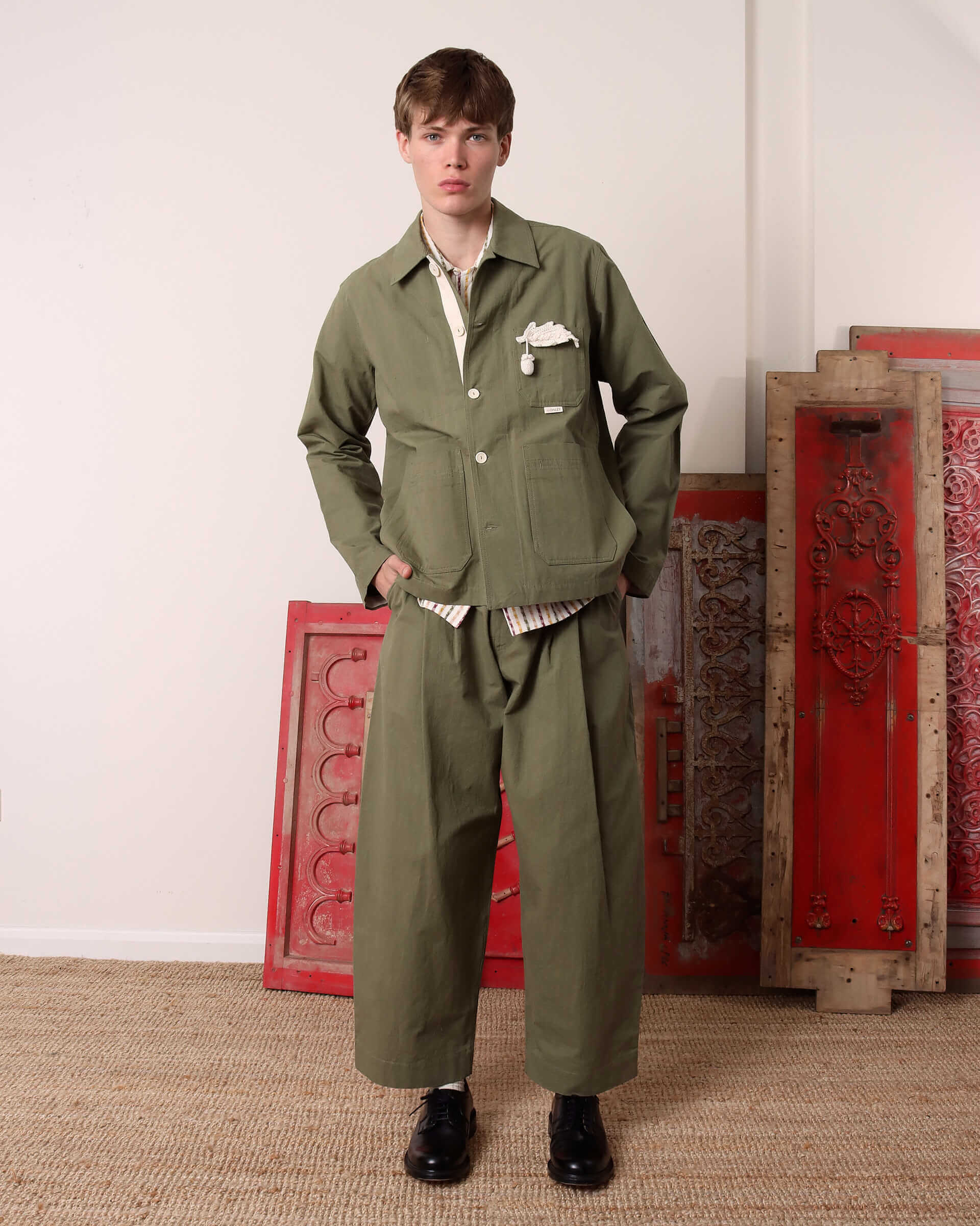A model wears the 'Clearence' Jacket in green with two buttons buttoned paired with the matching 'Clarence' Trousers in green.