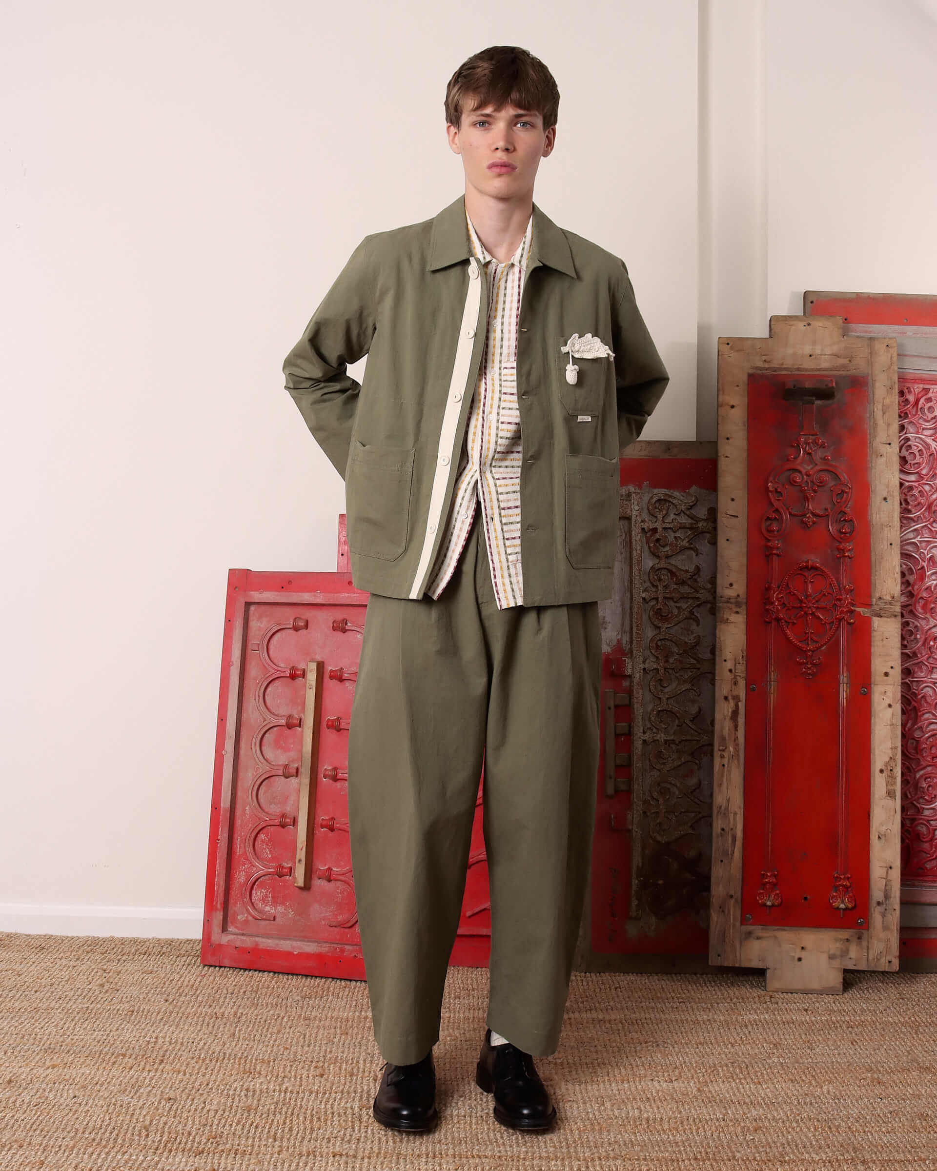A model wears the 'Clarence' Chore Jacket in green open with the matching green 'Clarence' Trousers.