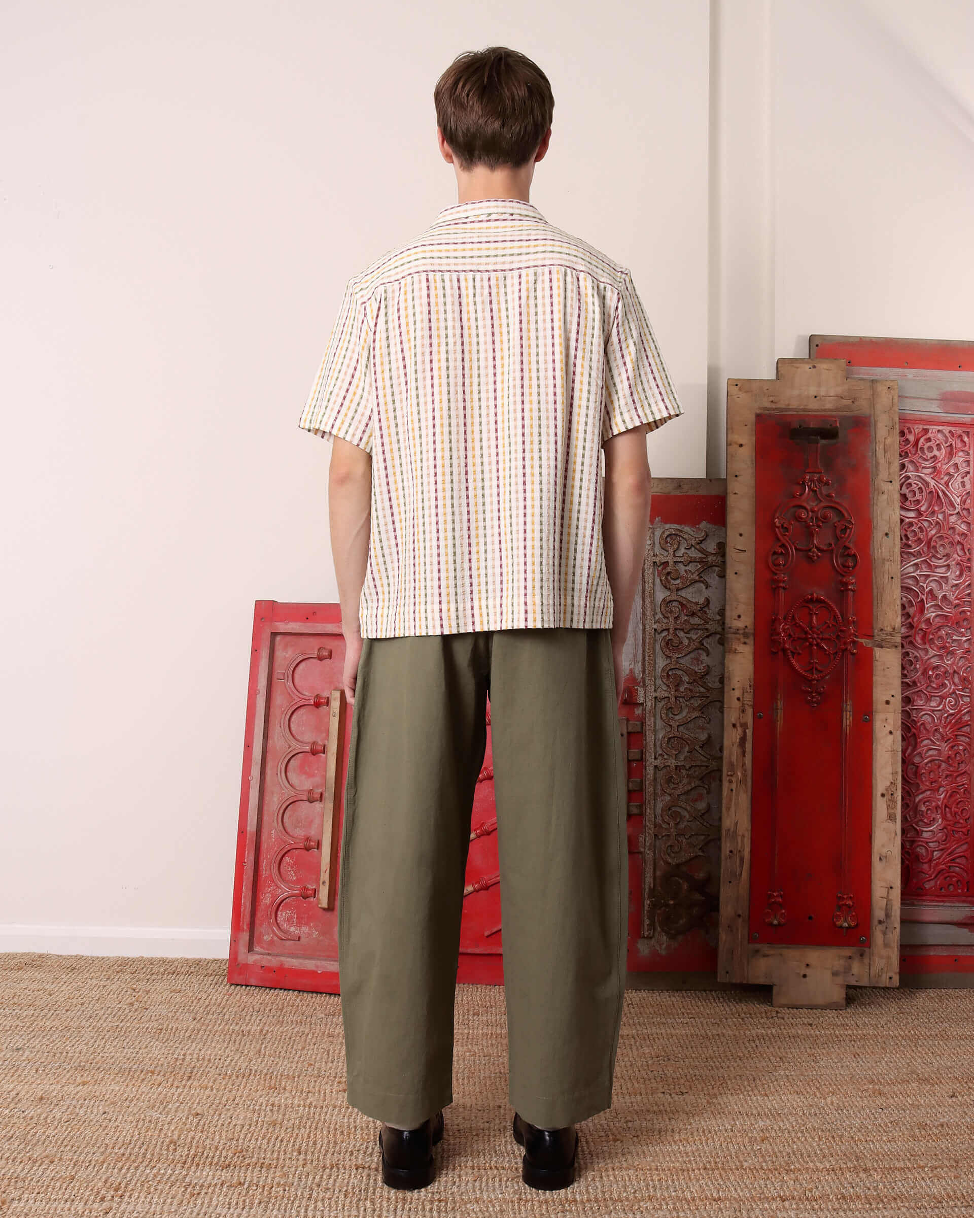 A model shows the back of the striped 'Almer' Short Sleeve Shirt.
