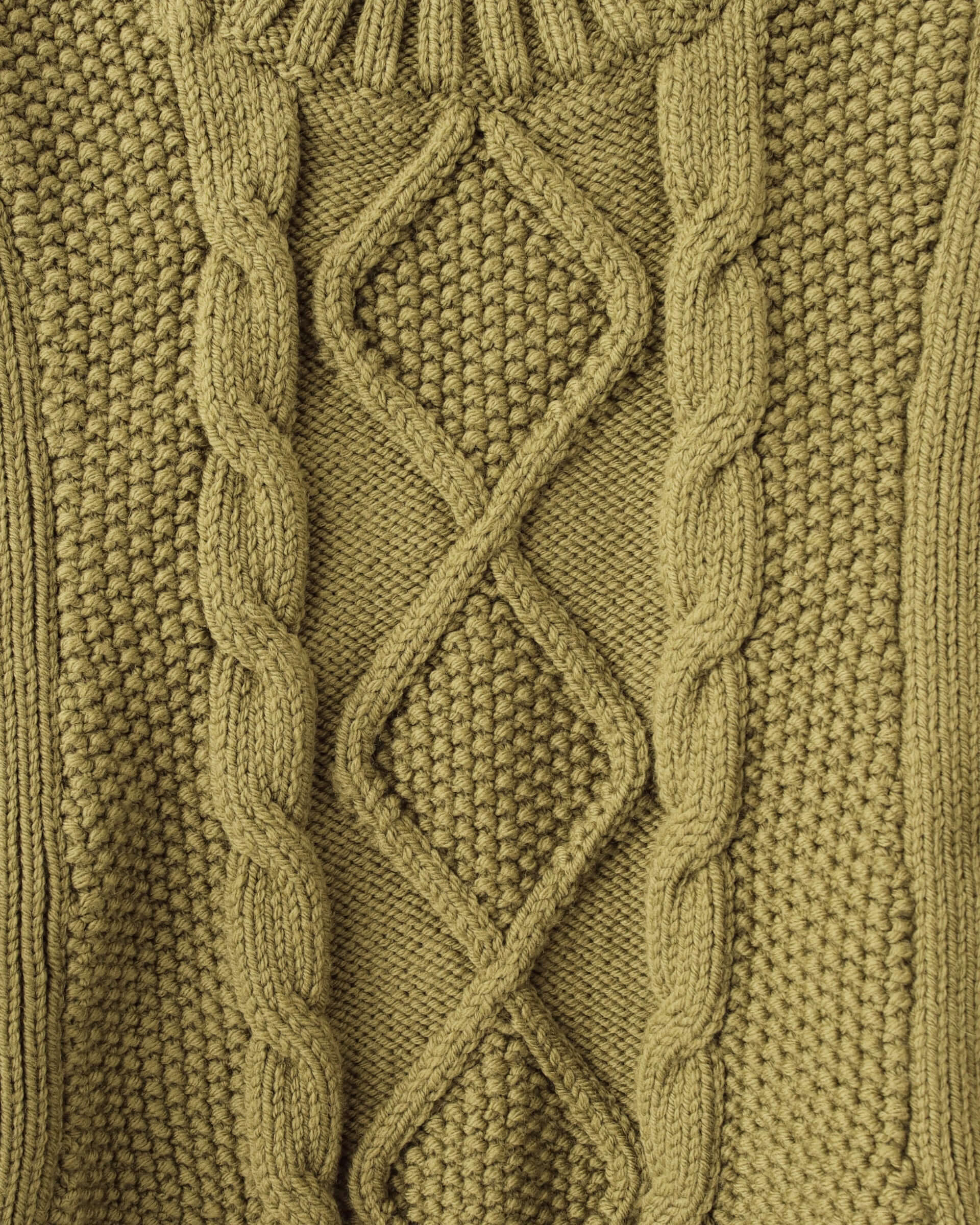 A close-up of the cable knit pattern featured on the 'Blandine' Vest in green.