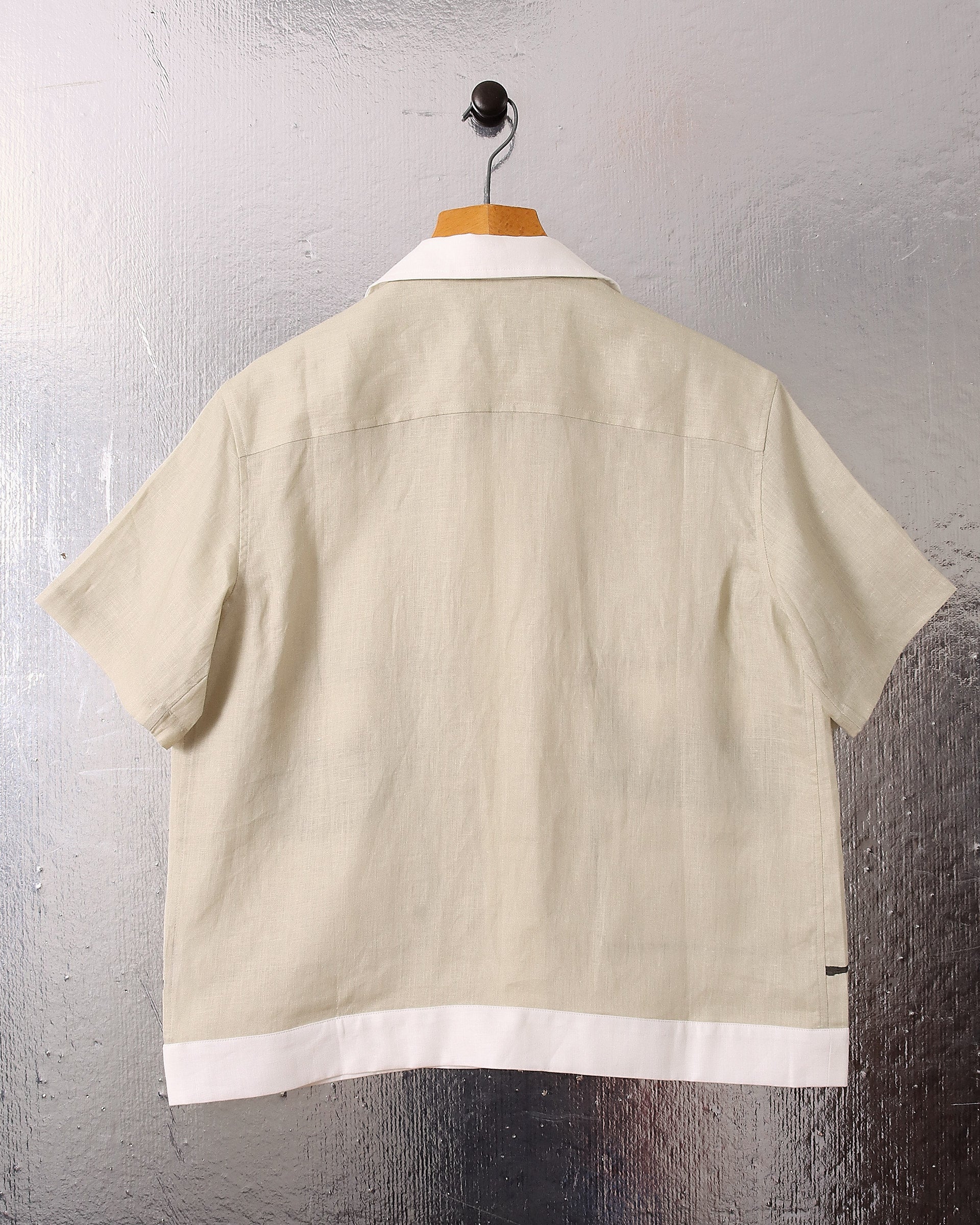 A flat image shows the back of the Lancashire' Sheep Shirt and the sage green and white border on the hem.