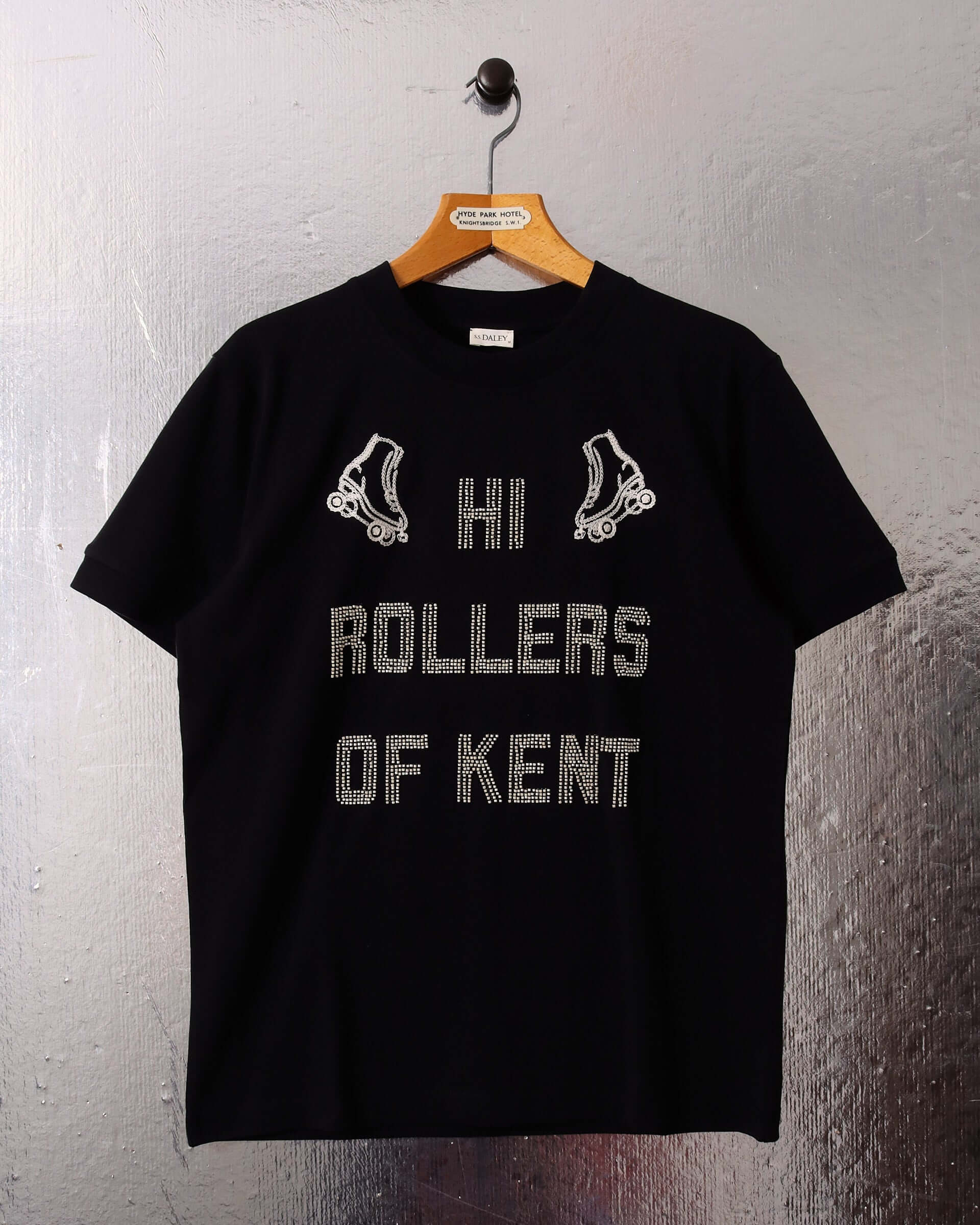 Flat image of 'Hi Rollers' gender neutral tee by S.S.DALEY in black and ecru embroidery.