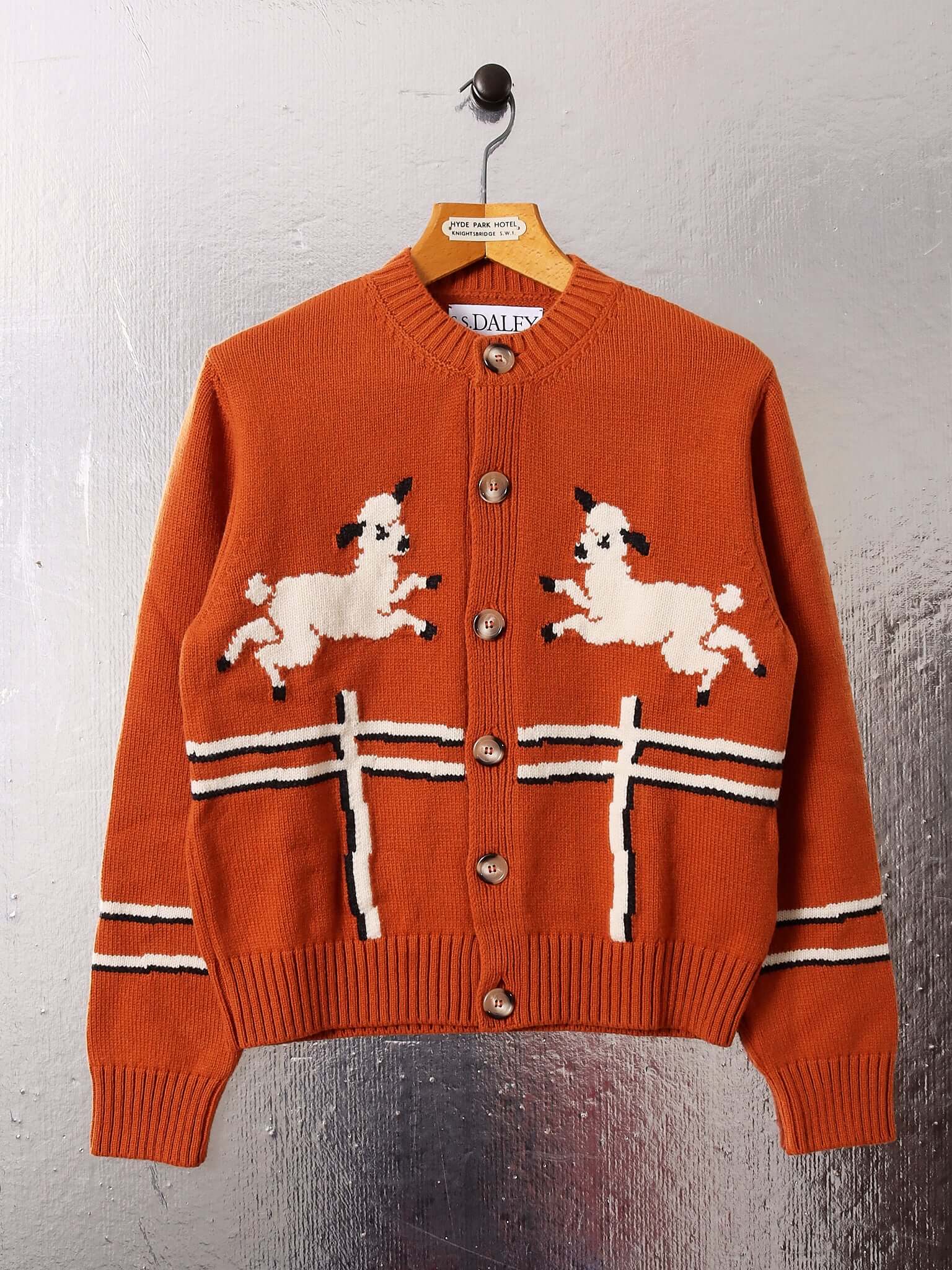 A flat image of the 'Cyril' Lamb Cardigan in orange tawny.