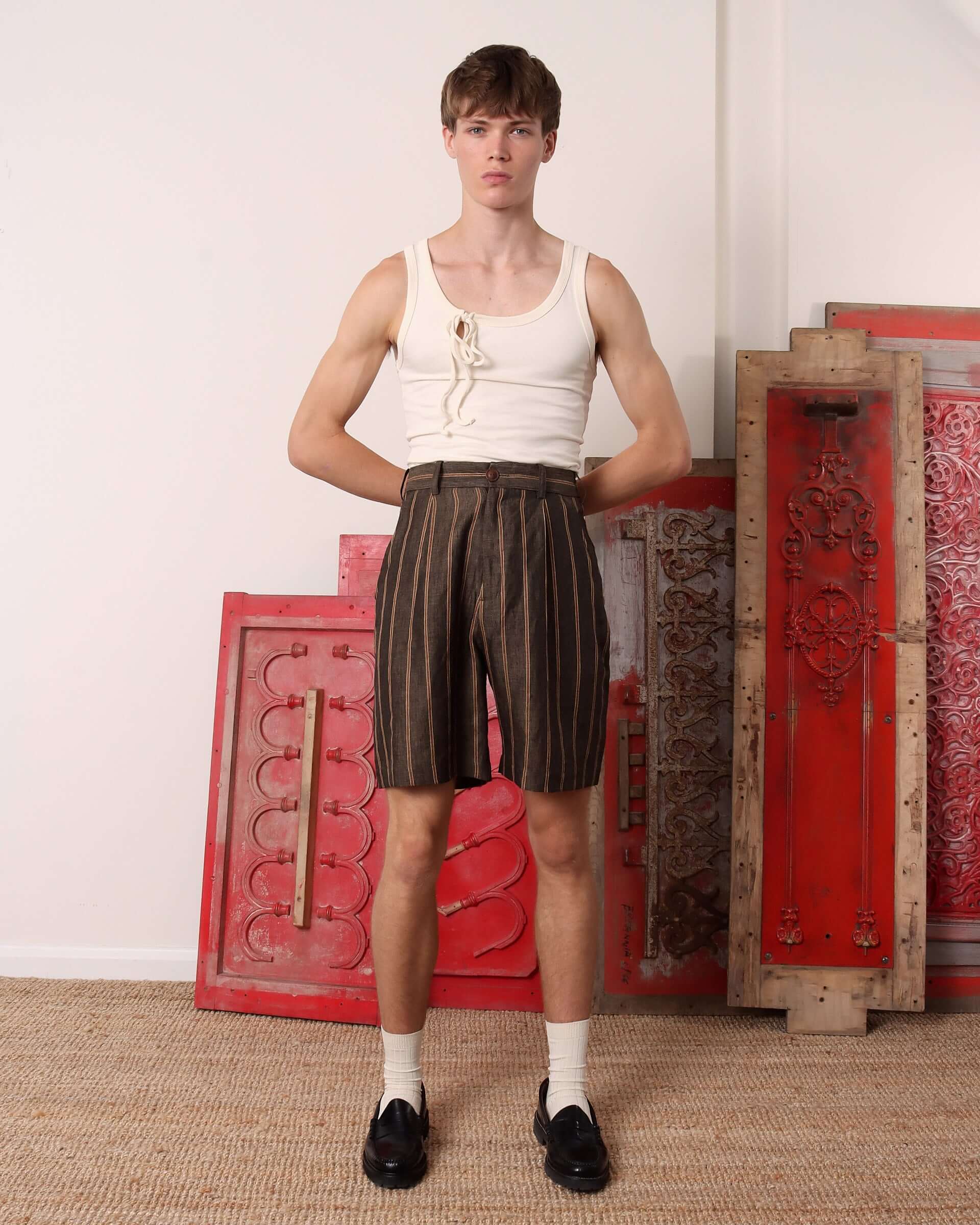 Model wearing the striped 'Rafferty' Pleated Suit Short in brown.