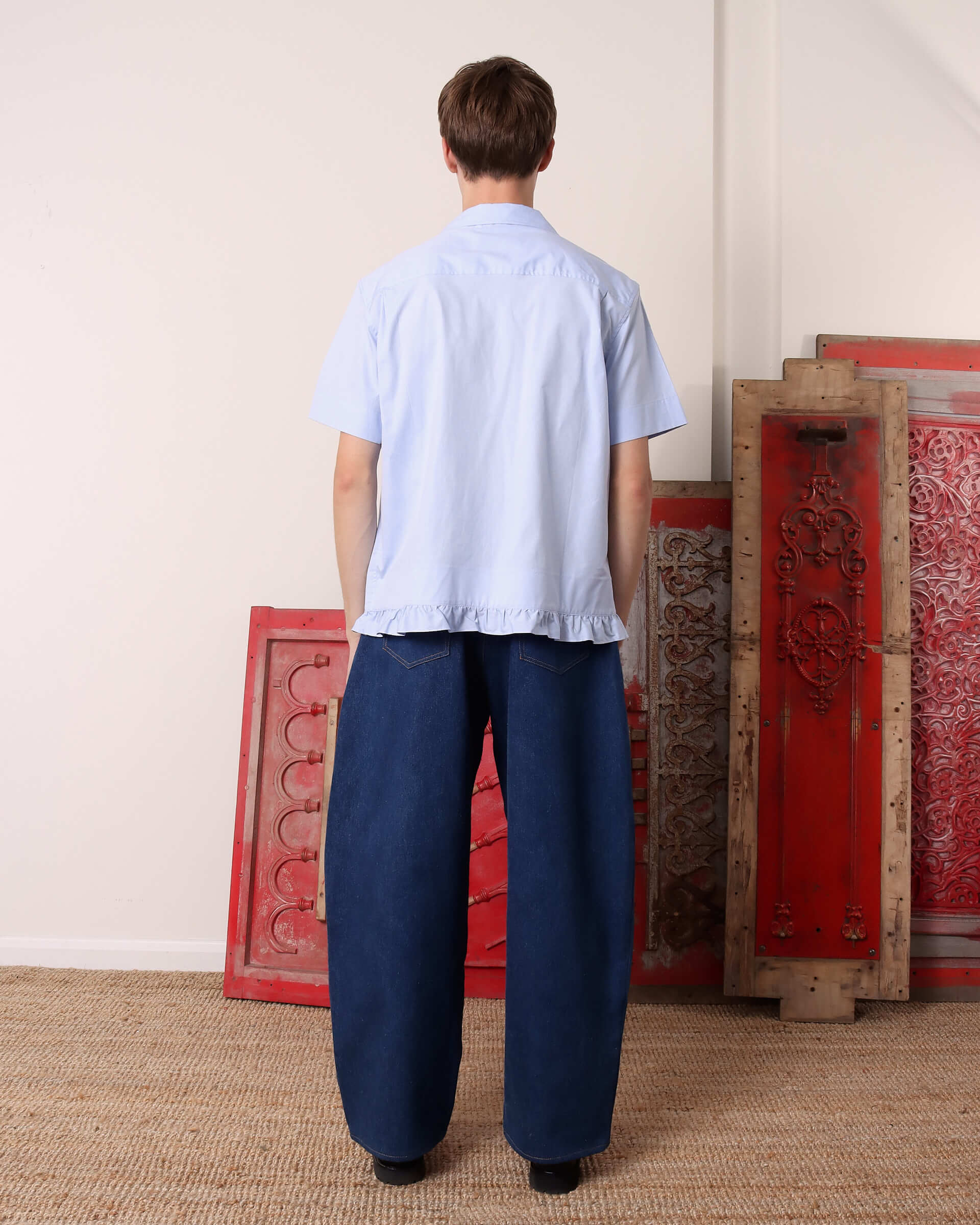A model shows the back of the 'Oxford' Pillowcase shirt in blue. 
