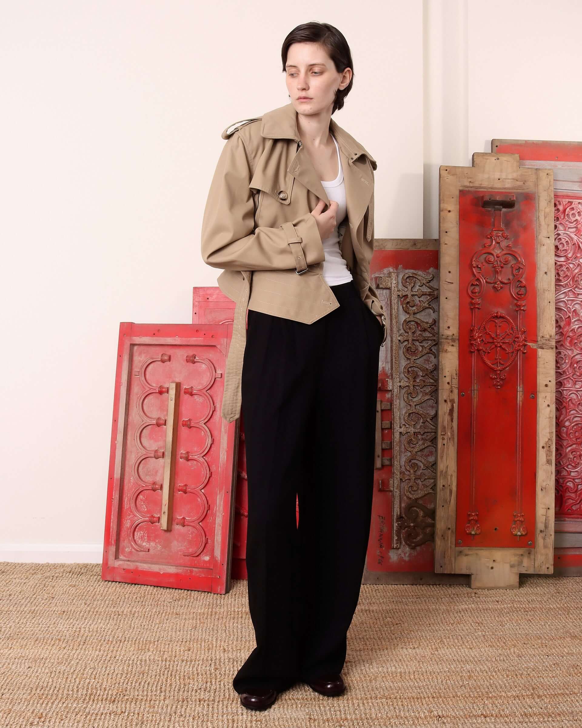 A model wearing the 'Eliza' Peplum Trench     unbuttoned with the belt unfastened.
