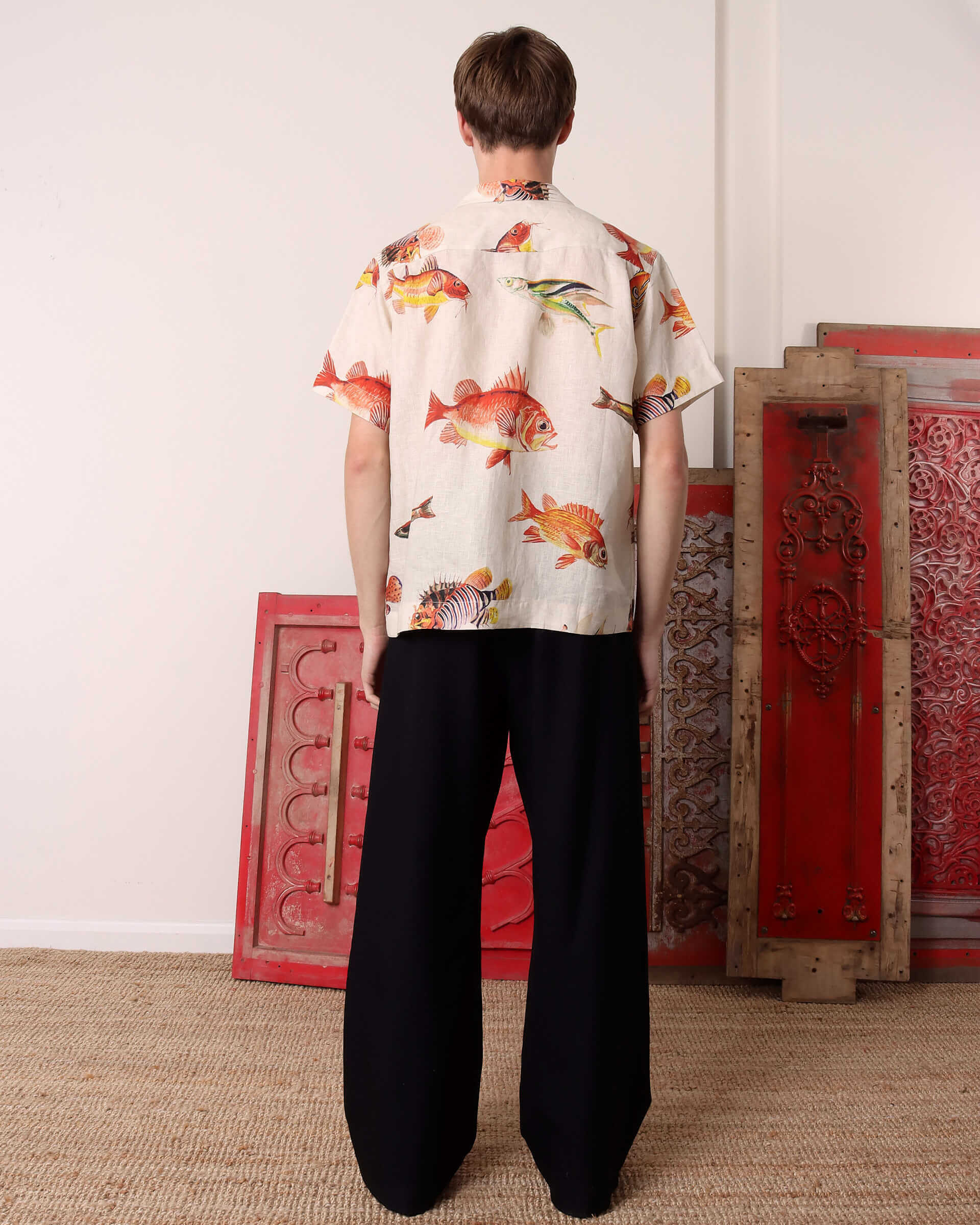 A model shows the back of the 'Benjamin' Shirt showing the allover fish print.