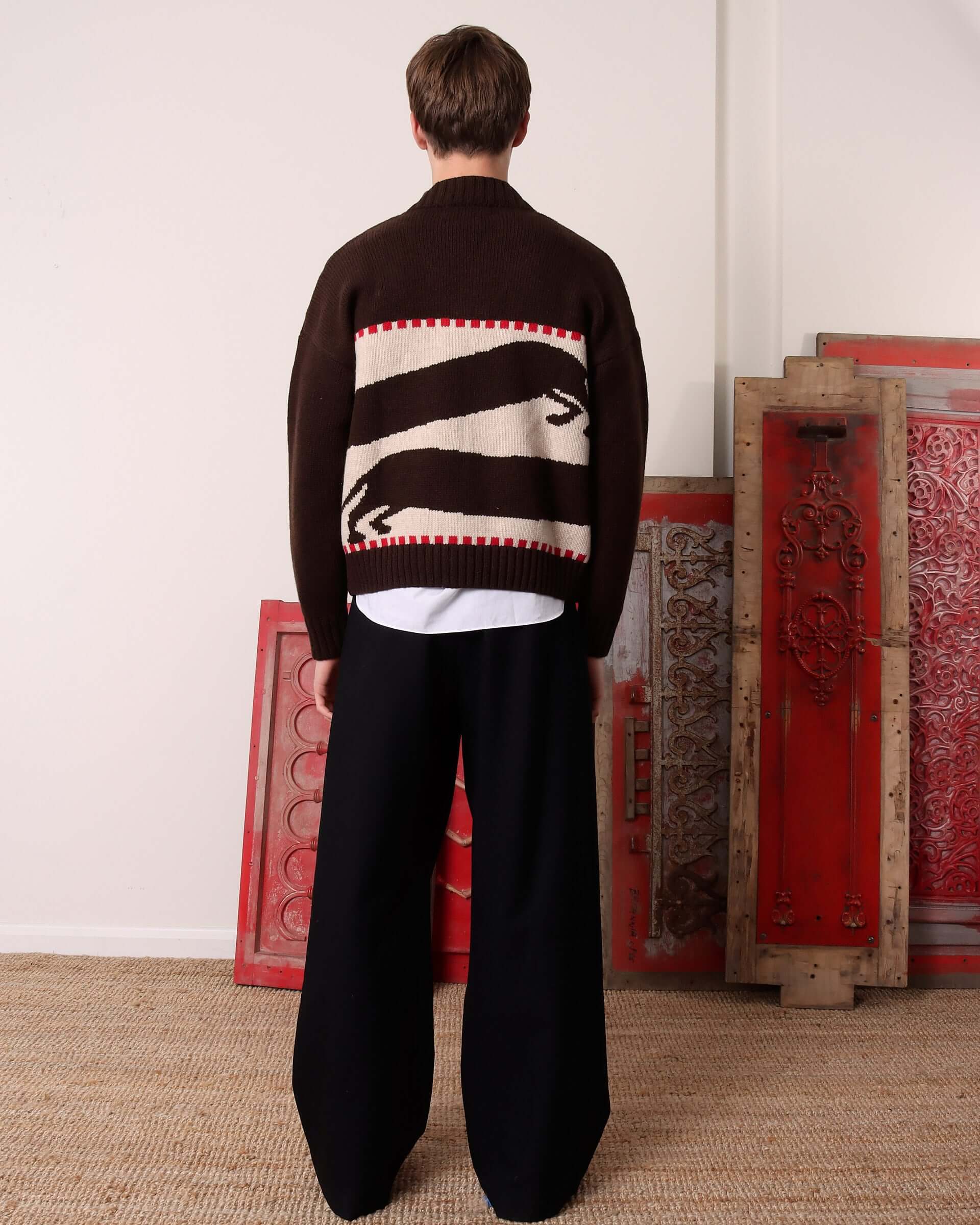 A model shows the back of the 'Harold' V-Neck Sweater Vest in brown and ecru and the two dachshund motifs.