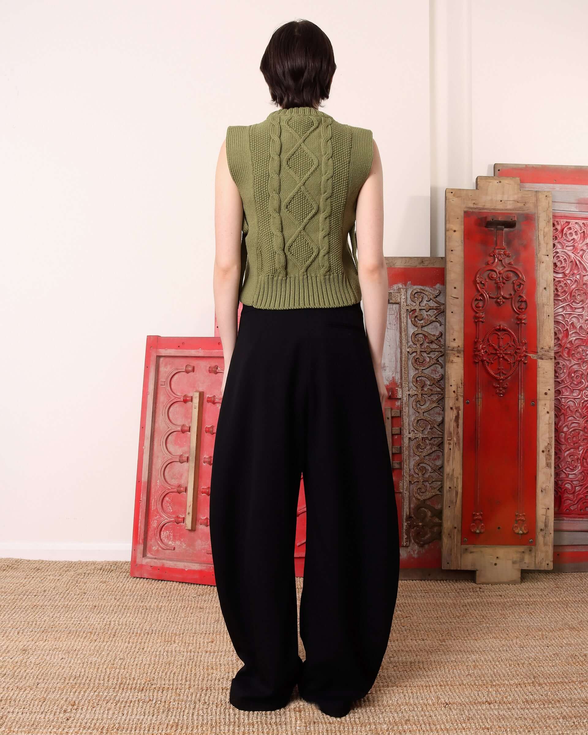 A model shows the back of the green 'Blandine' Vest.