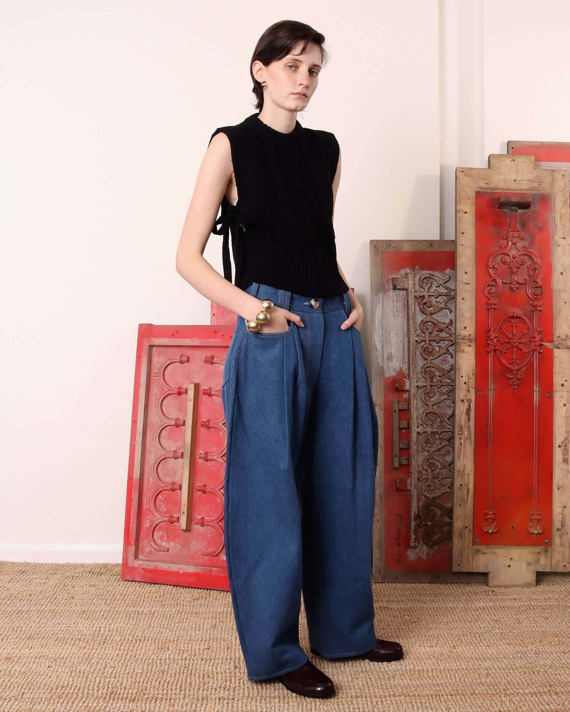 A model wears the black 'Blandine' Vest with the side-tie details tied in a bow.