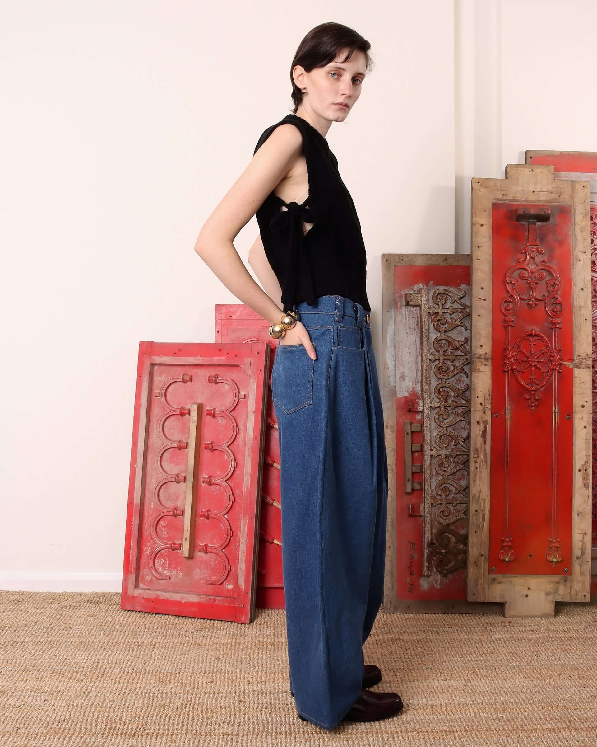 A model shows the side of the black 'Blandine' Vest and the tied side-tie detail.