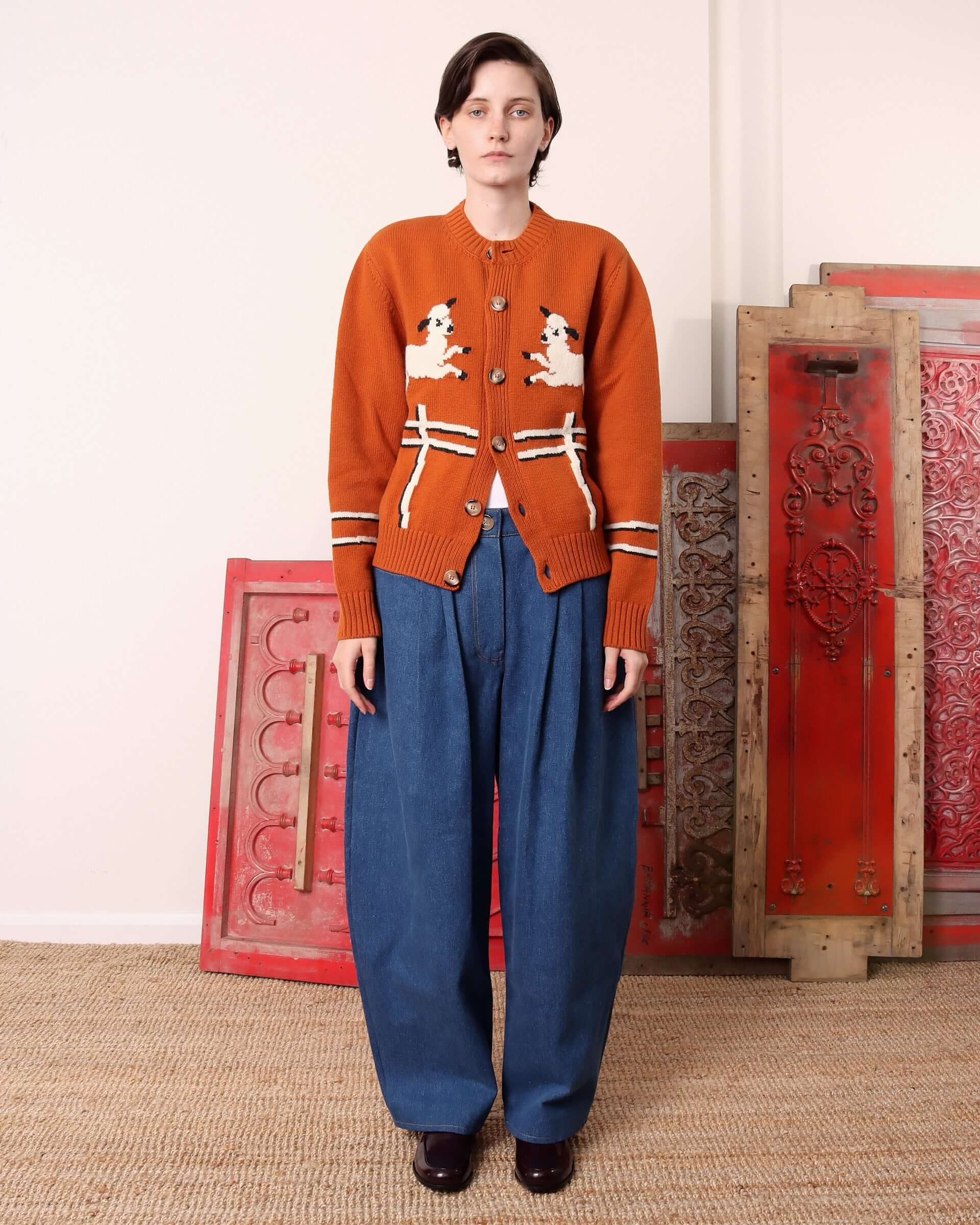 A model wears the 'Cyril' Lamb Cardigan in tawny partially buttoned up.