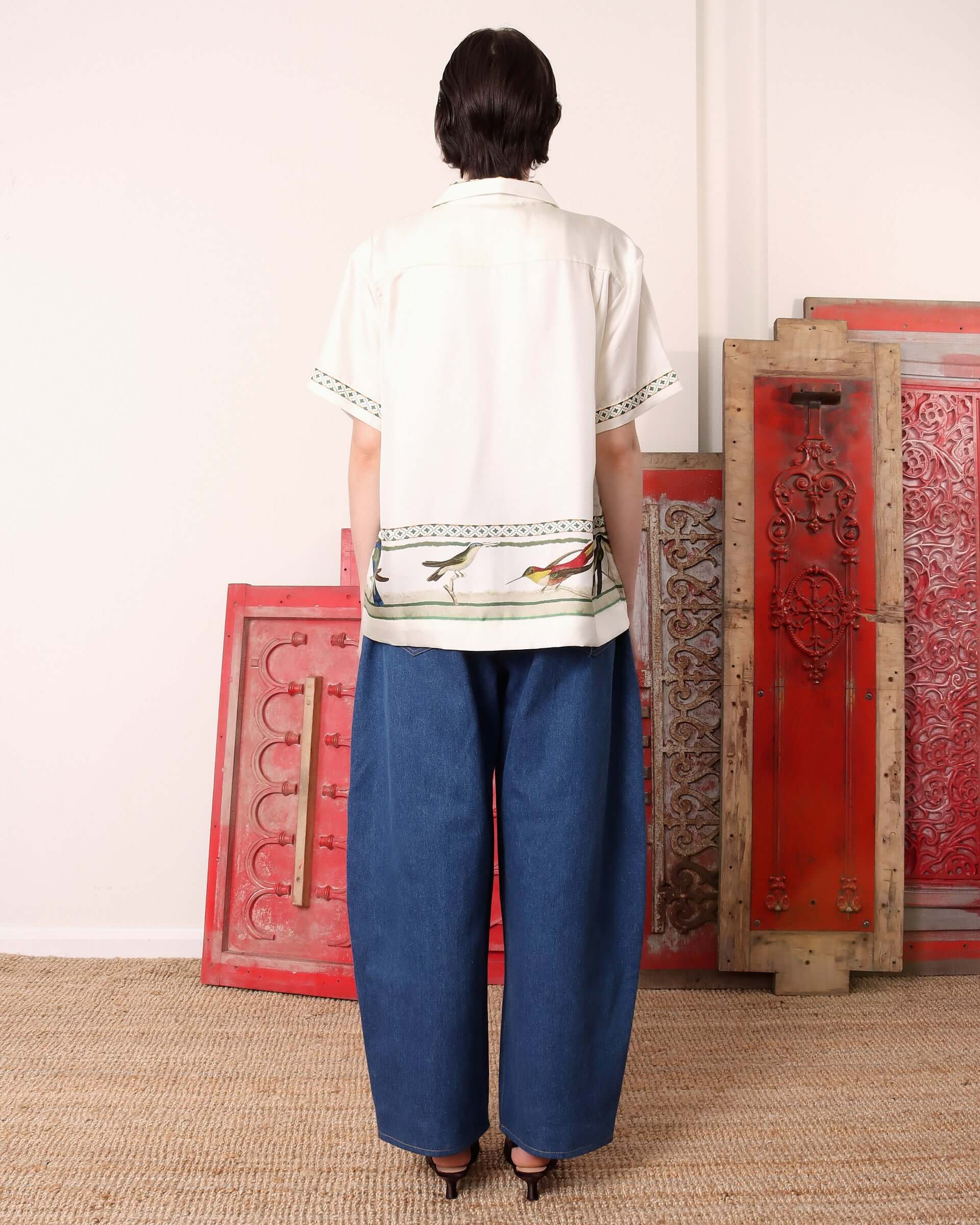 A model wearing the 'Birdwatcher' shirt and showing the back of the garment and its boxy fit.