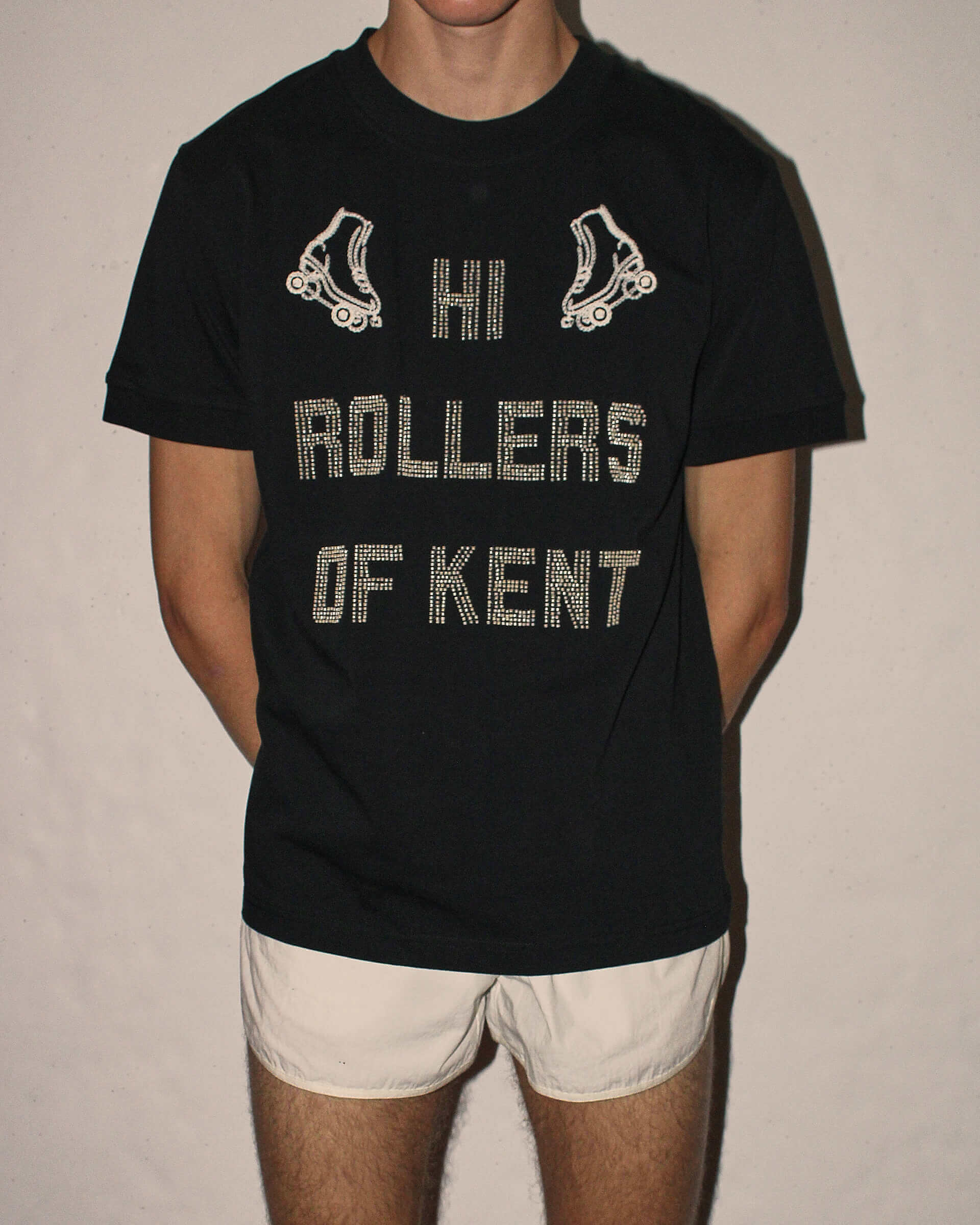 A detailed shot of the 'Hi Rollers' T-shirt, showing the detailed beading reading "Hi Rollers of Kent" with two mirrored embroidered roller skates.