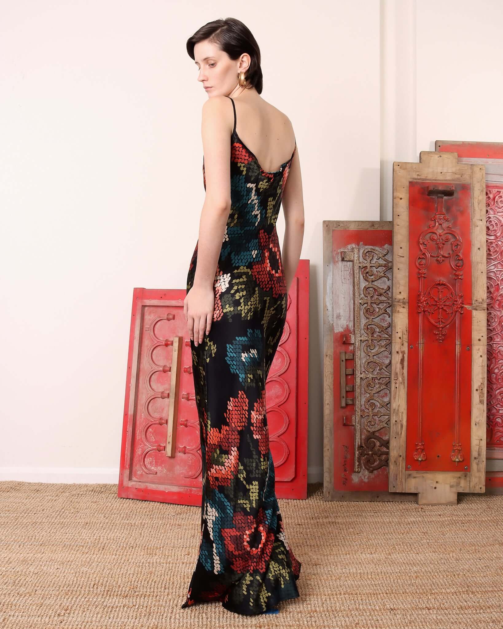 A model showing the back of the black and floral 'Willow' Slip Dress.