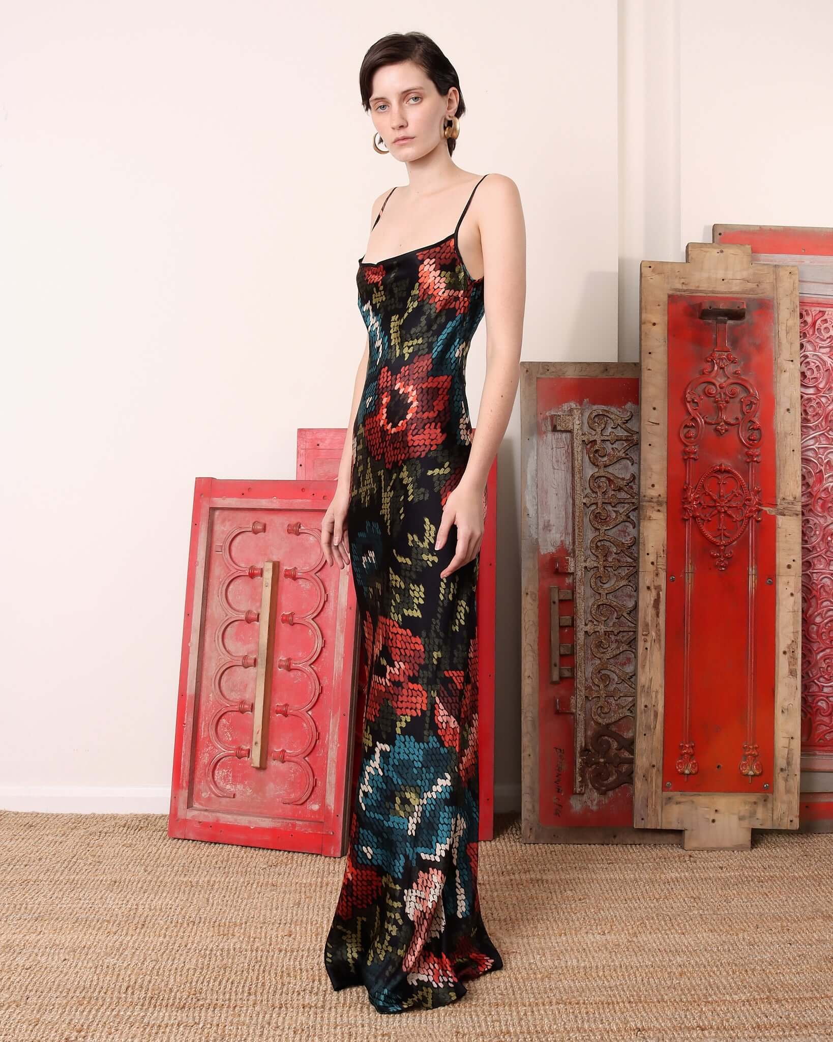 A model showing the side of the black and floral print 'Willow' Slip Dress and its floor-length hem.