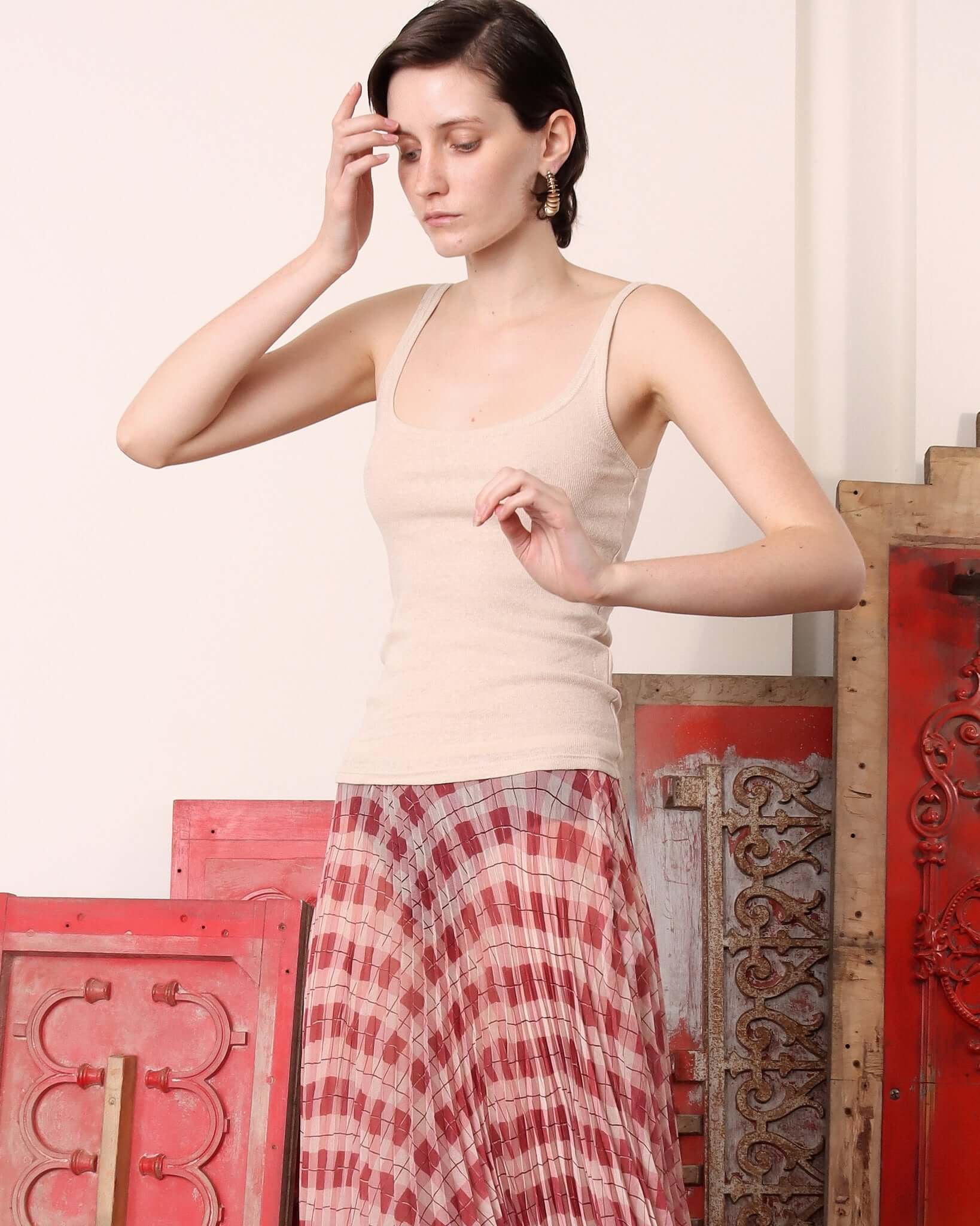 A close-up of a model in the 'Kate' Skirt in argyle paired with a cream vest.