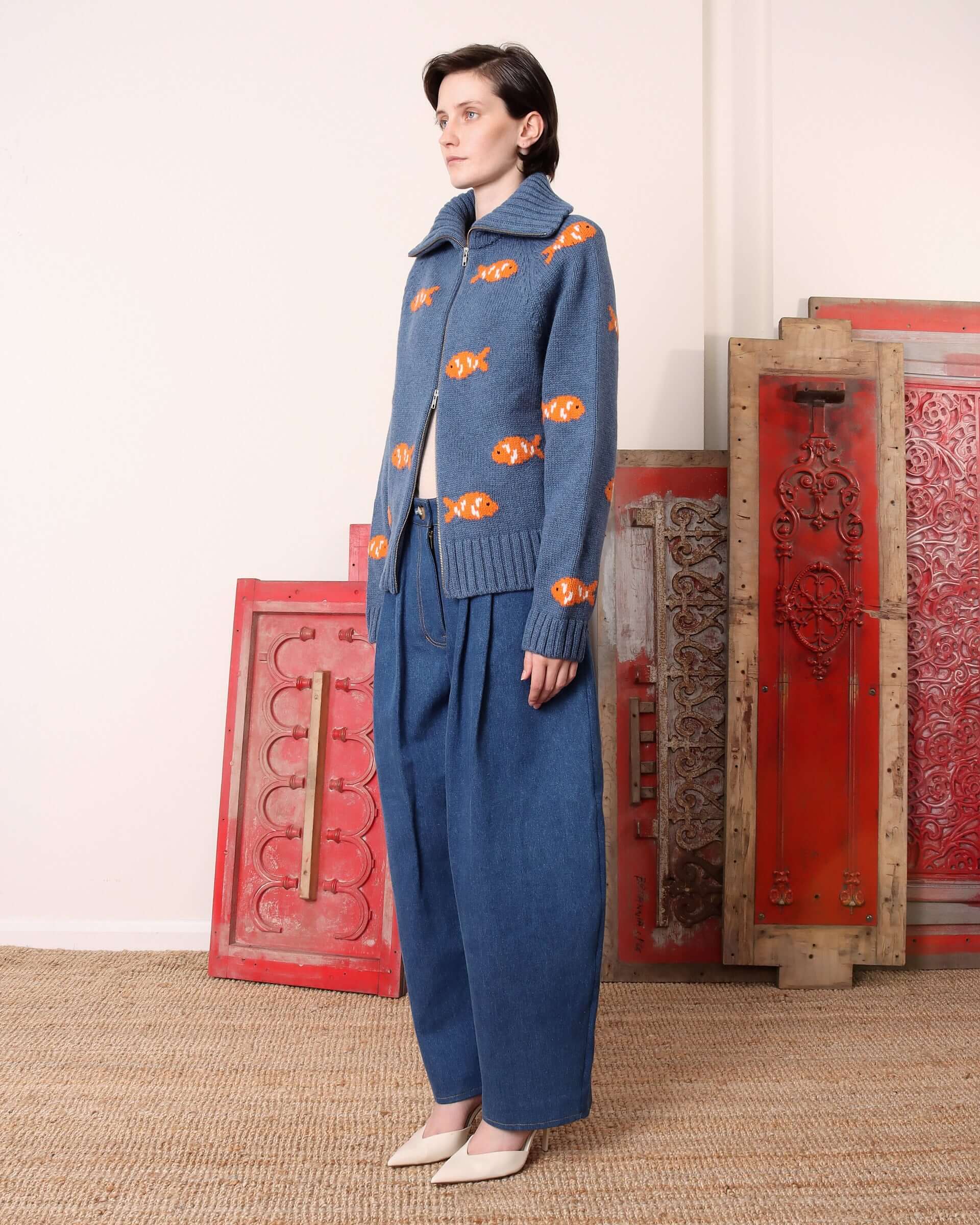 A model wears the 'Archie' Knit with the zip open halfway from the bottom showing the versatile styling opportunities. 