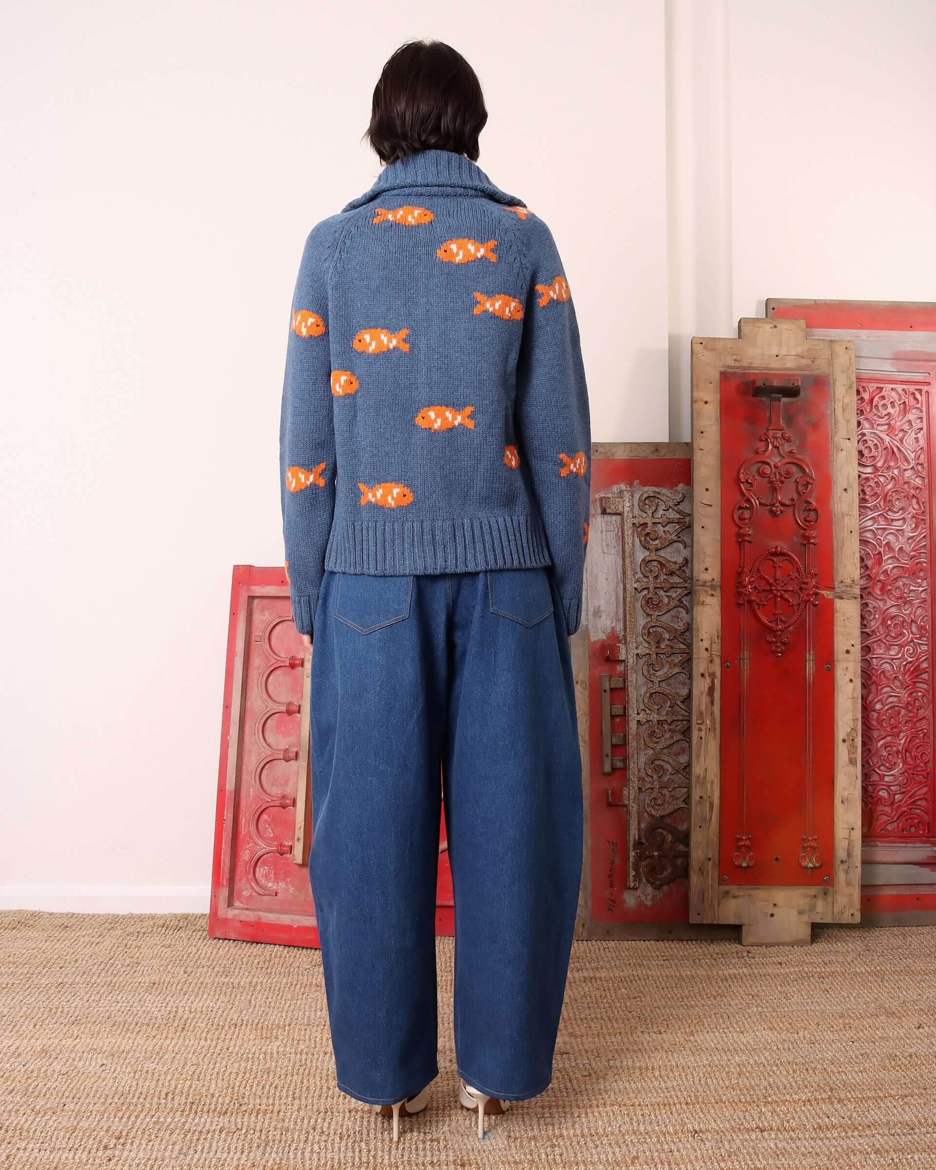 A model shows the back of the 'Archie' knit and its all-over goldfish intarsia pattern and folded ribbed collar. 