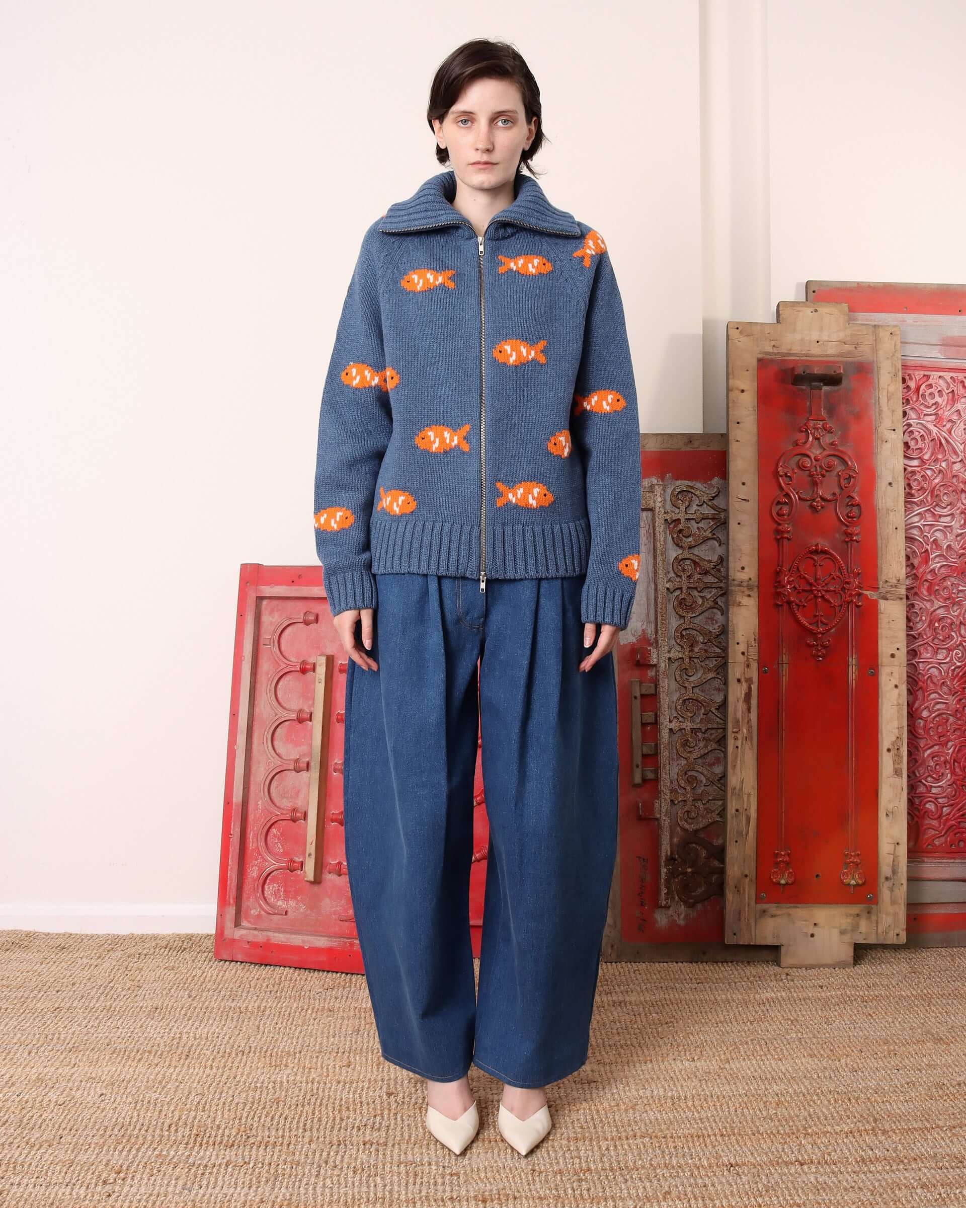 A model wears the 'Archie' Knit zipped up to just below the collar, showing the relaxed, boxy fit of the sweater.