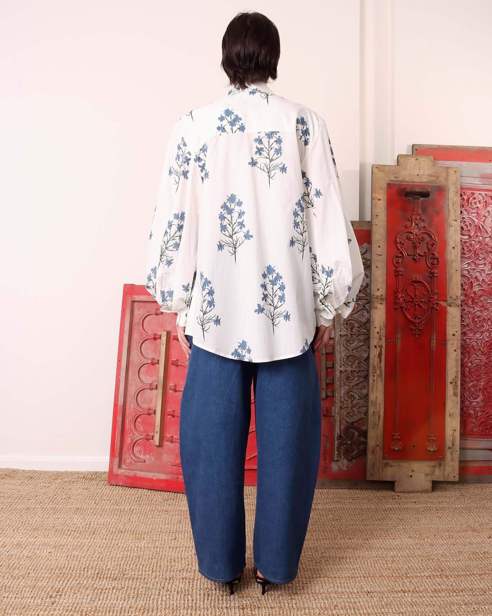 A model shows the back of the 'Clem' Long Sleeve Shirt and it's long rounded sleeves.
