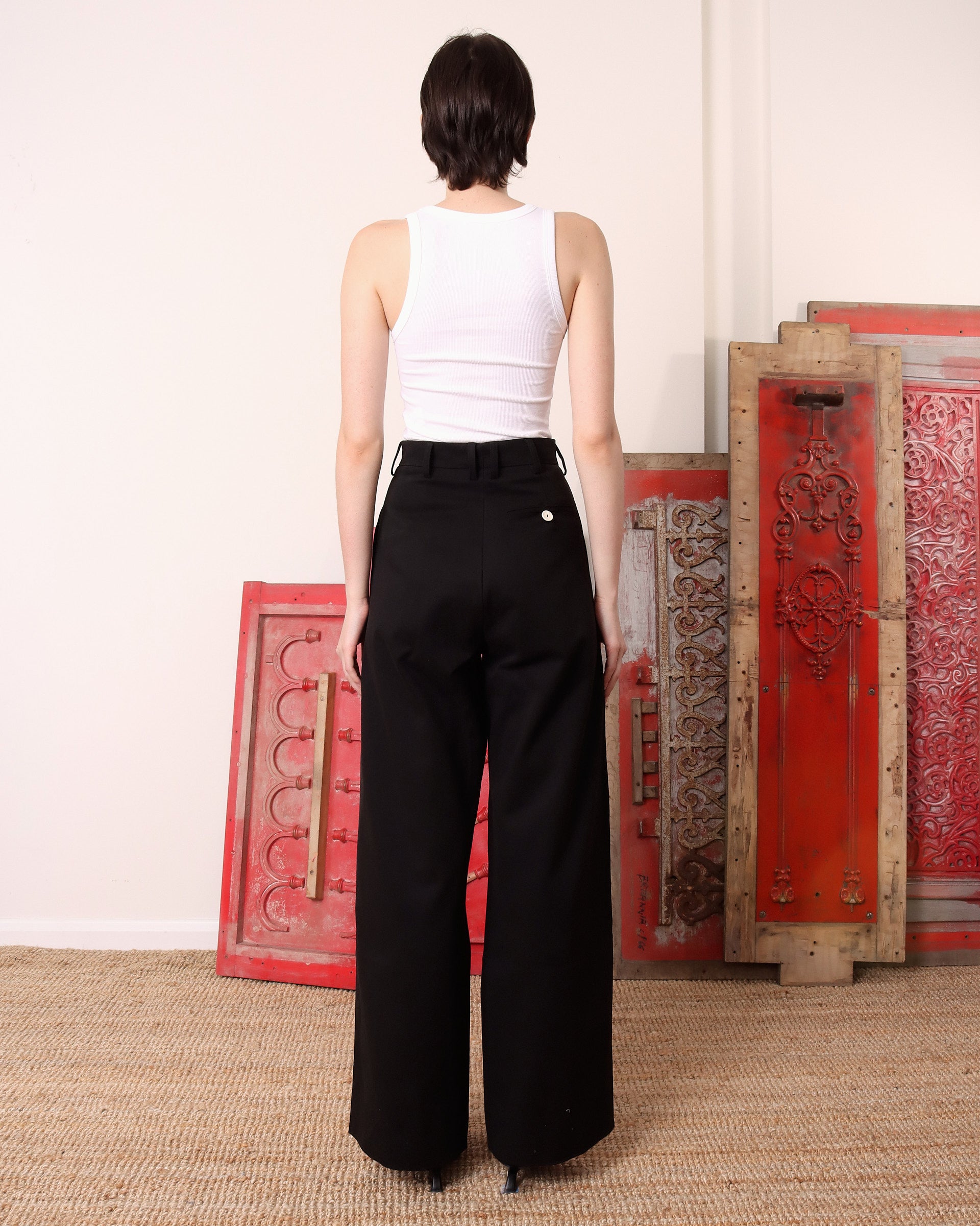 A model shows the back of the black 'Georgina' Trousers with the back pocket visible.