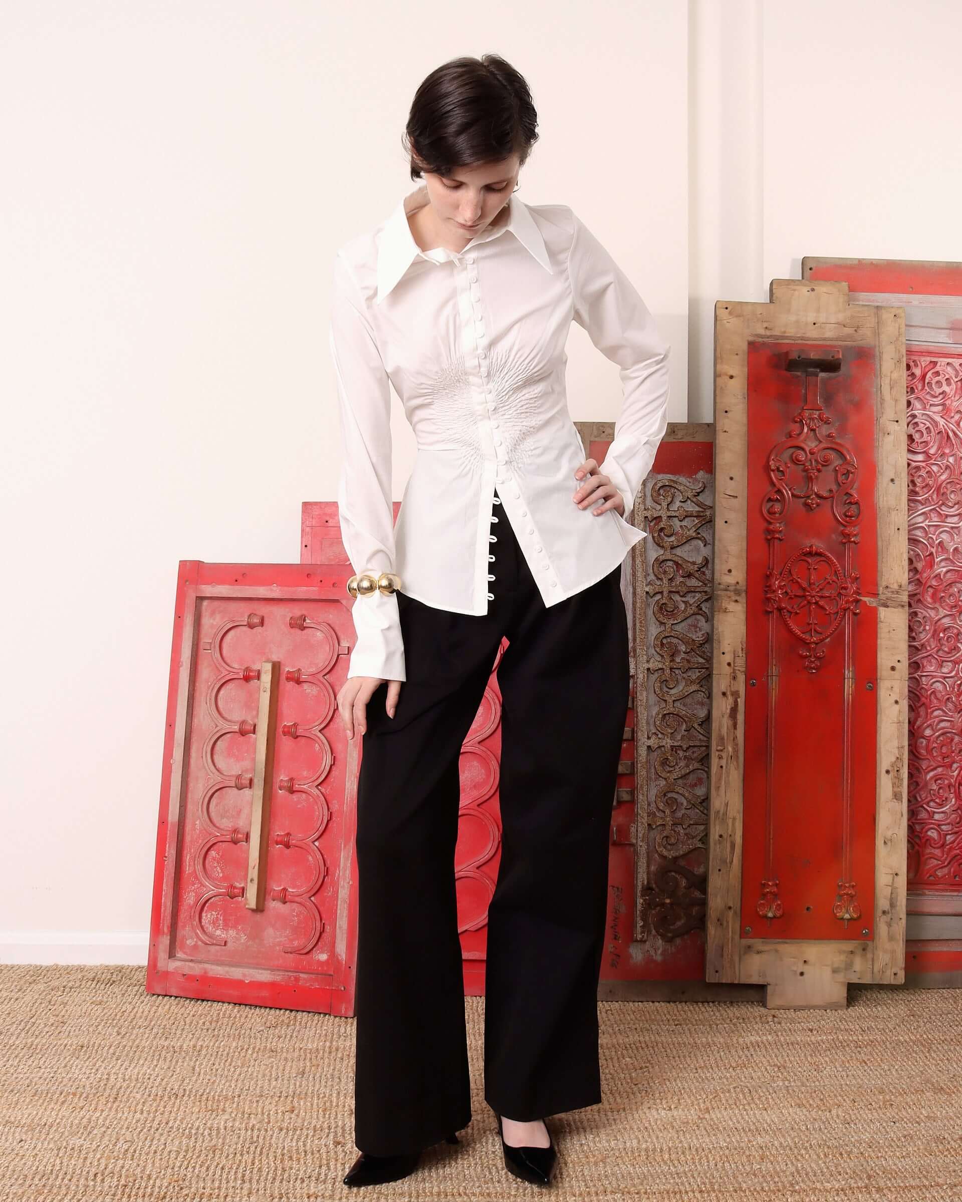 A model wears the 'Eva' Circle shirt unbuttoned at the lower portion of the shirt and buttoned to the collar at the upper portion. 