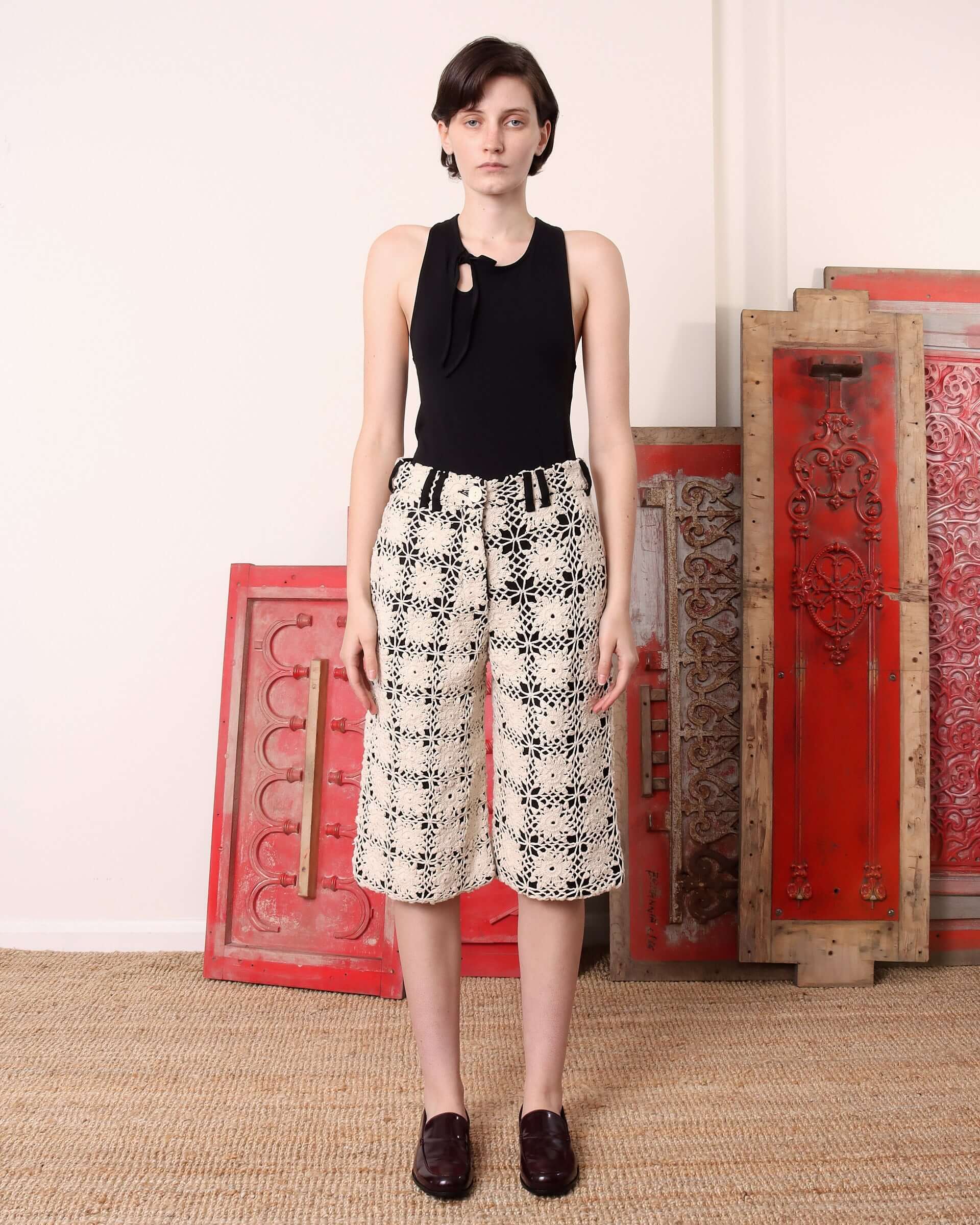 A model wears the 'Ida' Crochet Shorts with a black base and ecru crochet.