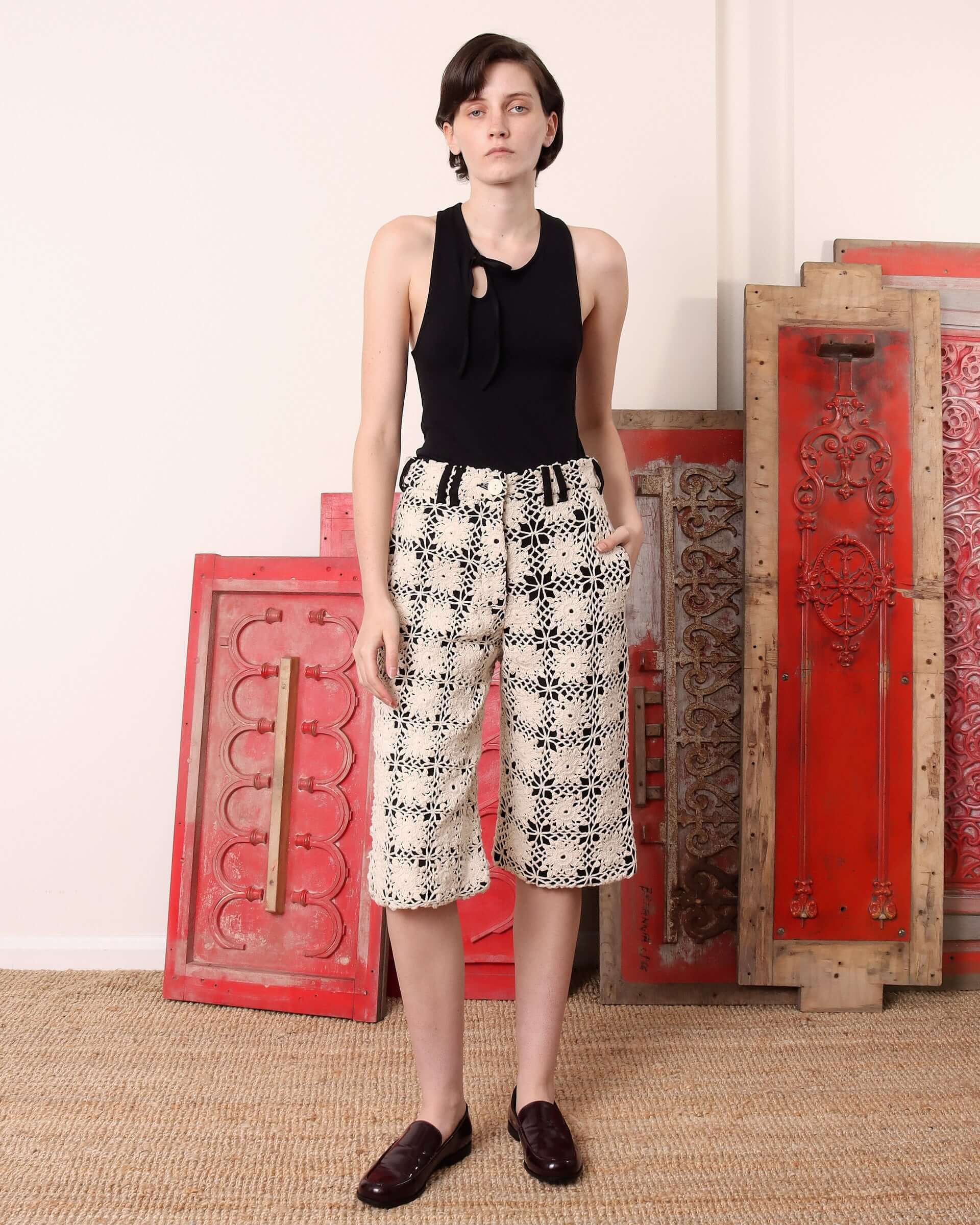 A model wears the 'Ida' Crochet Knee length Shorts paired with a black 'Cochrane' Vest tucked in.