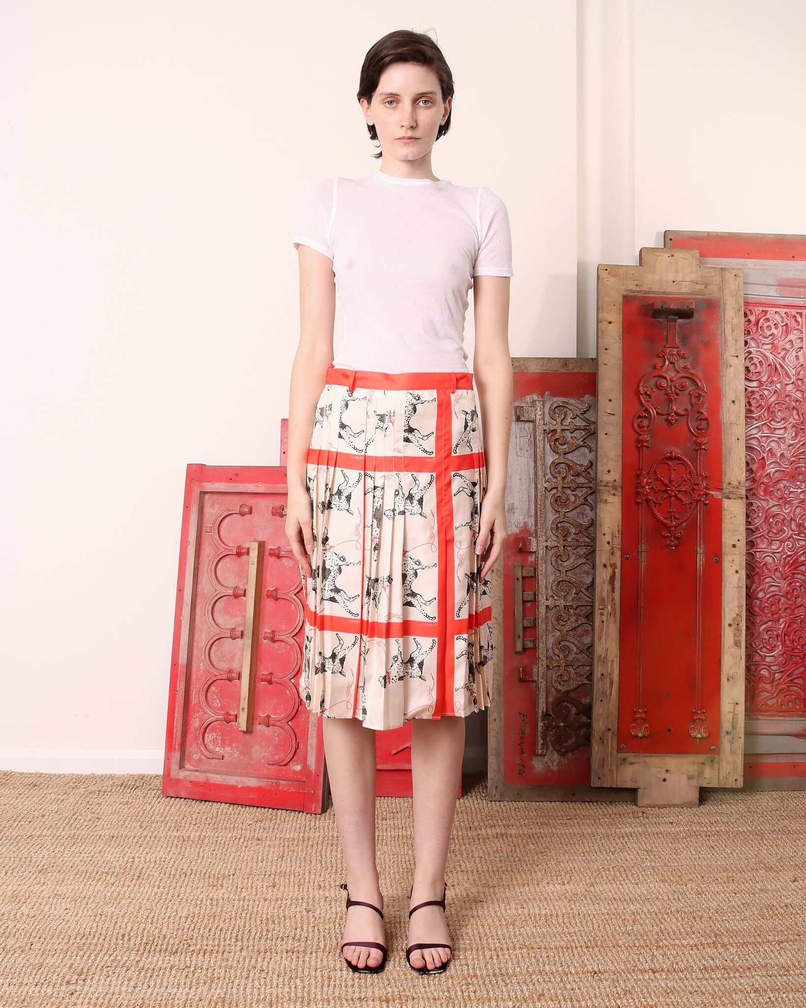 A model stands straight wearing the 'Pointer' Skirt showing the mid length.