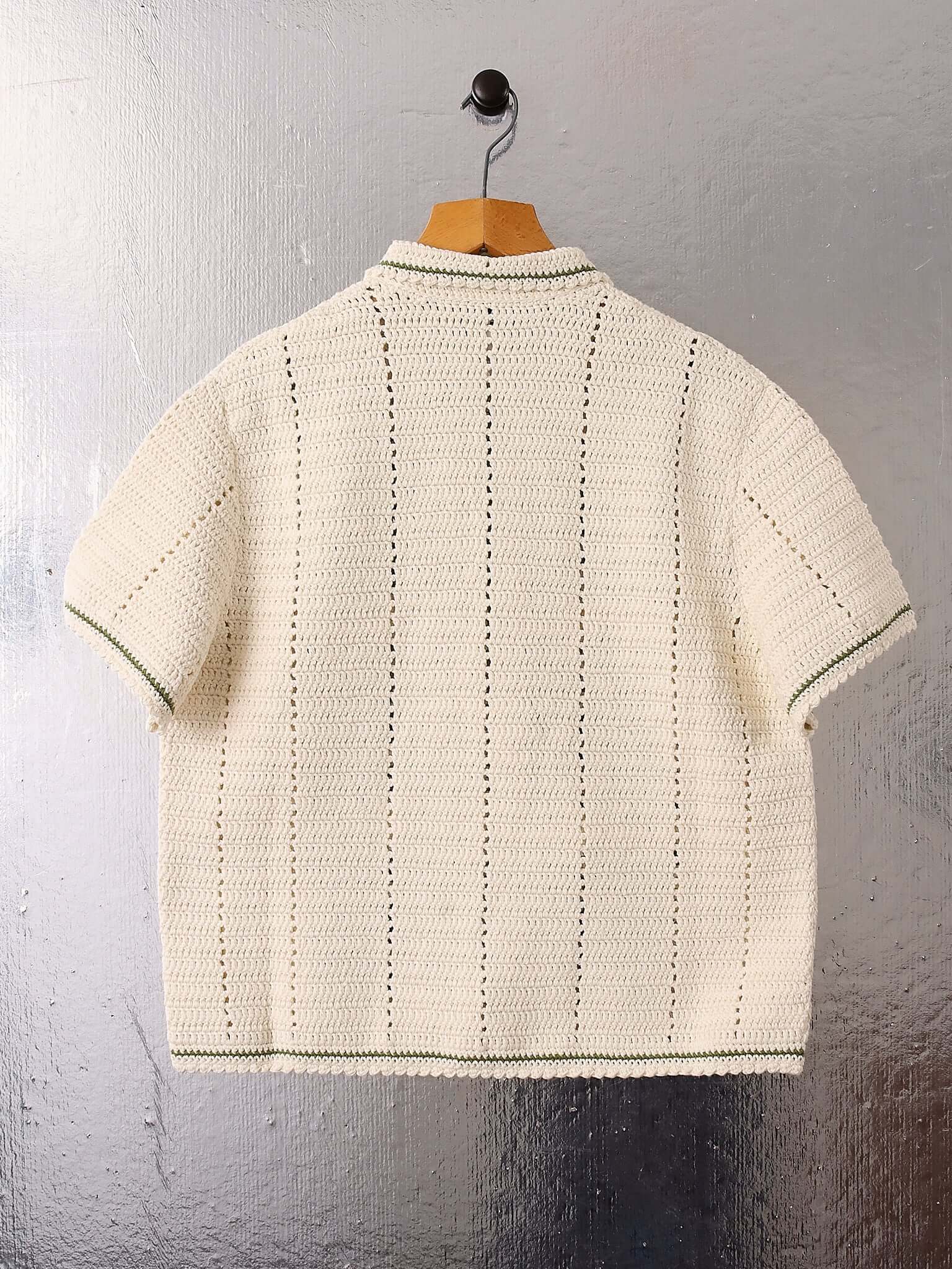 A flat shot of the back of the 'Abel' Crochet Shirt in cream and green crochet.