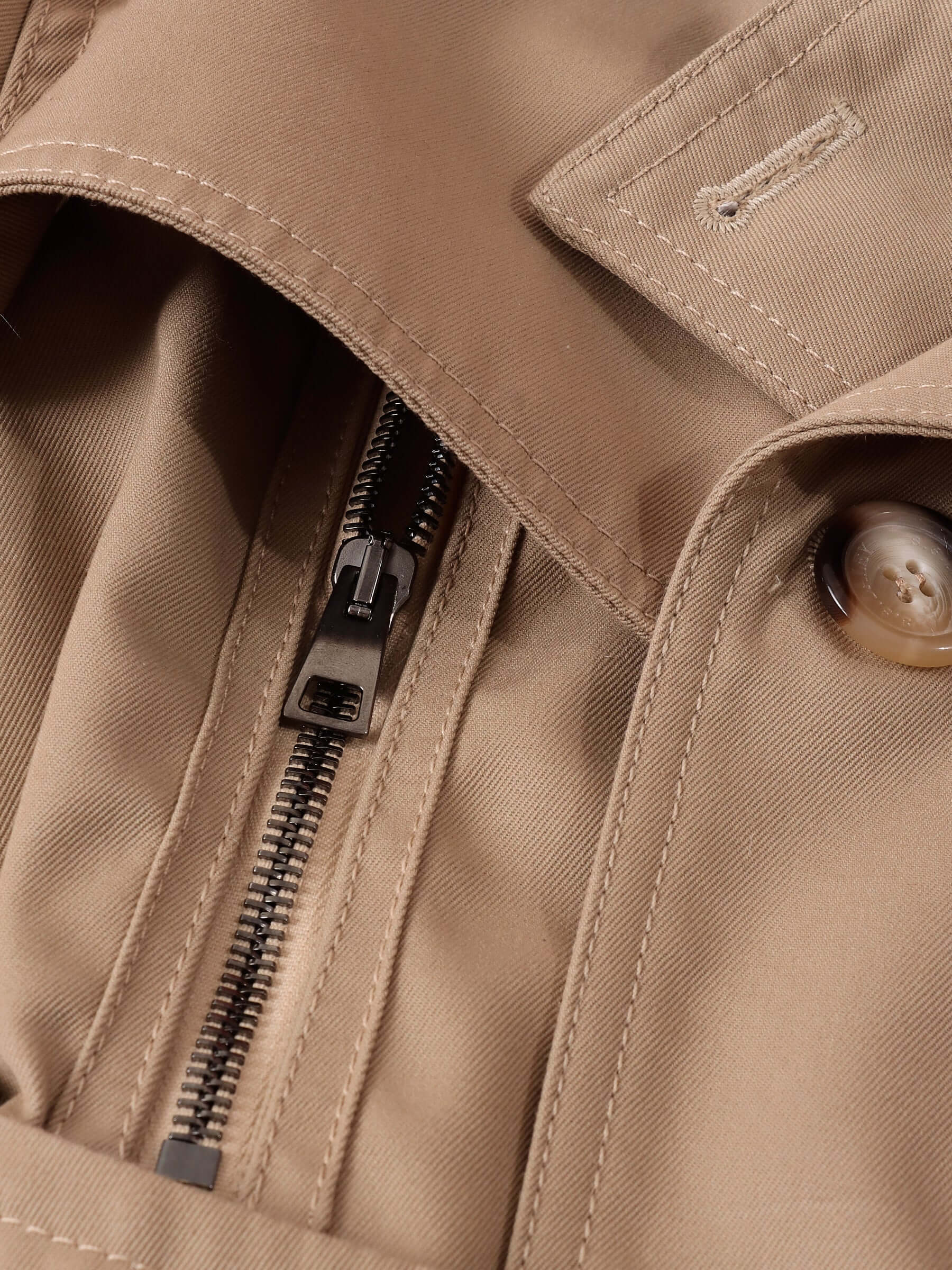 A close-up of the dark beige gaberdine fabric of the 'Eliza' Peplum Trench.