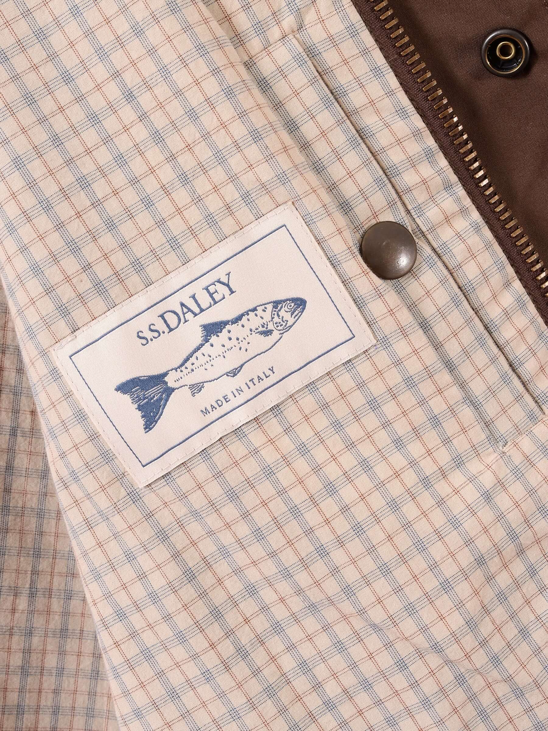 Close up of the waxed blouson jackets checked lining and inner pocket, as well as an S.S.DALEY made in Italy logo.